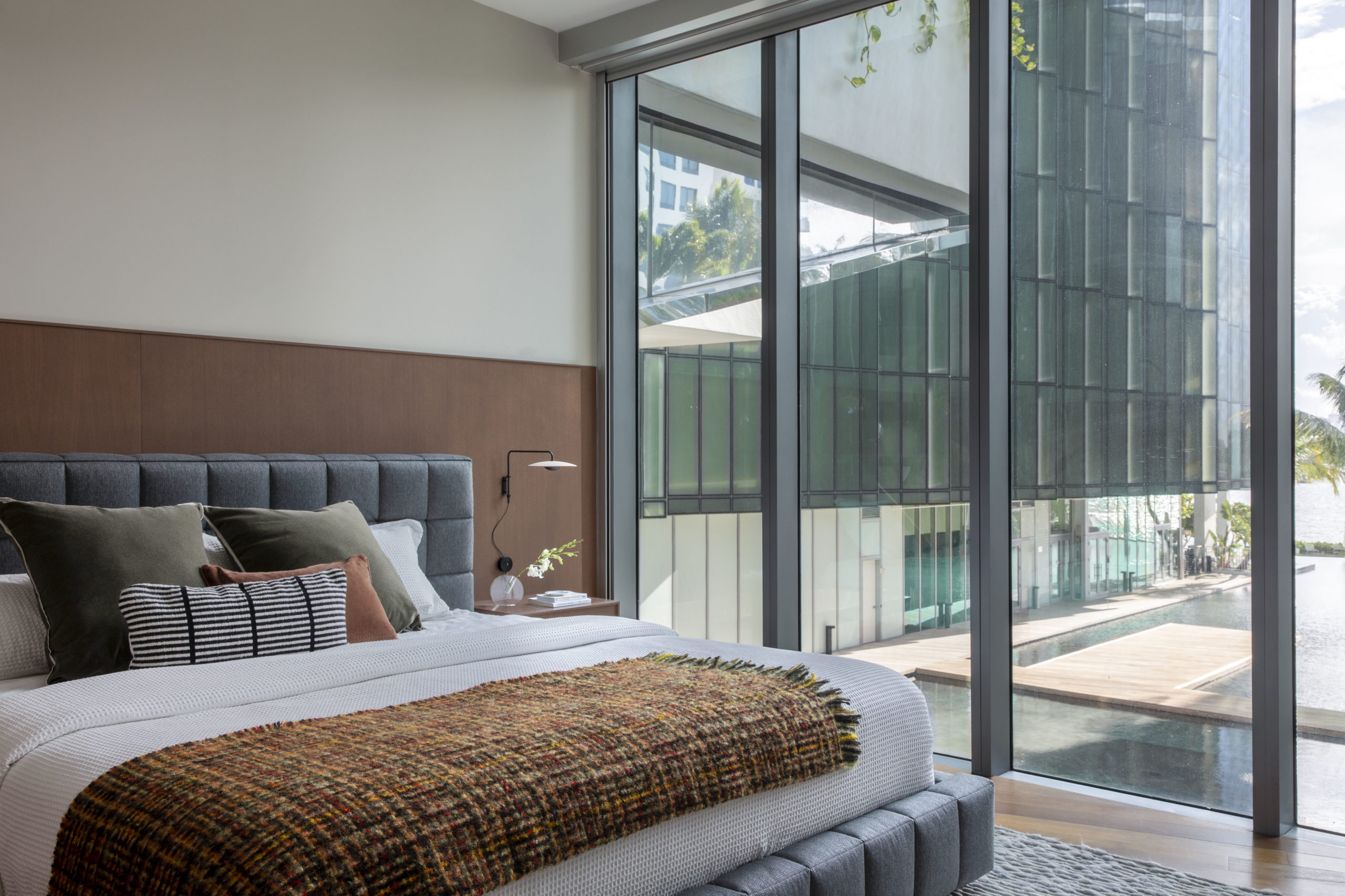 quarto master com cama de casal, mesa de cabeceira e porta da varanda