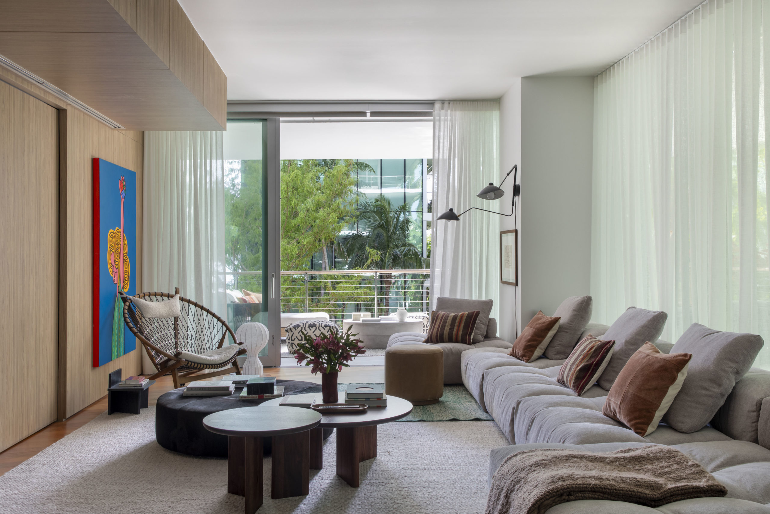 living com cortina de linho, sofá ilha, mesinhas de centro, poltrona e varanda