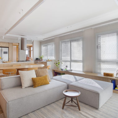 sala de estar com sofá, persiana e tapete em tom off-white