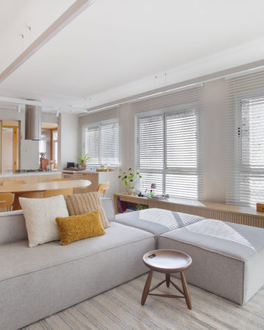 sala de estar com sofá, persiana e tapete em tom off-white