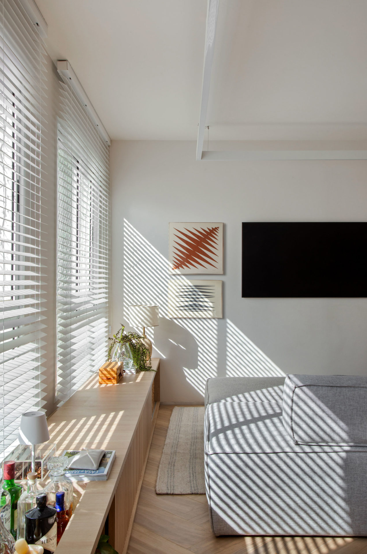 persiana branca na janela ofertando luz natural à sala