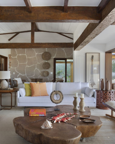 sala de casa de praia com sofá, mesa de centro de madeira