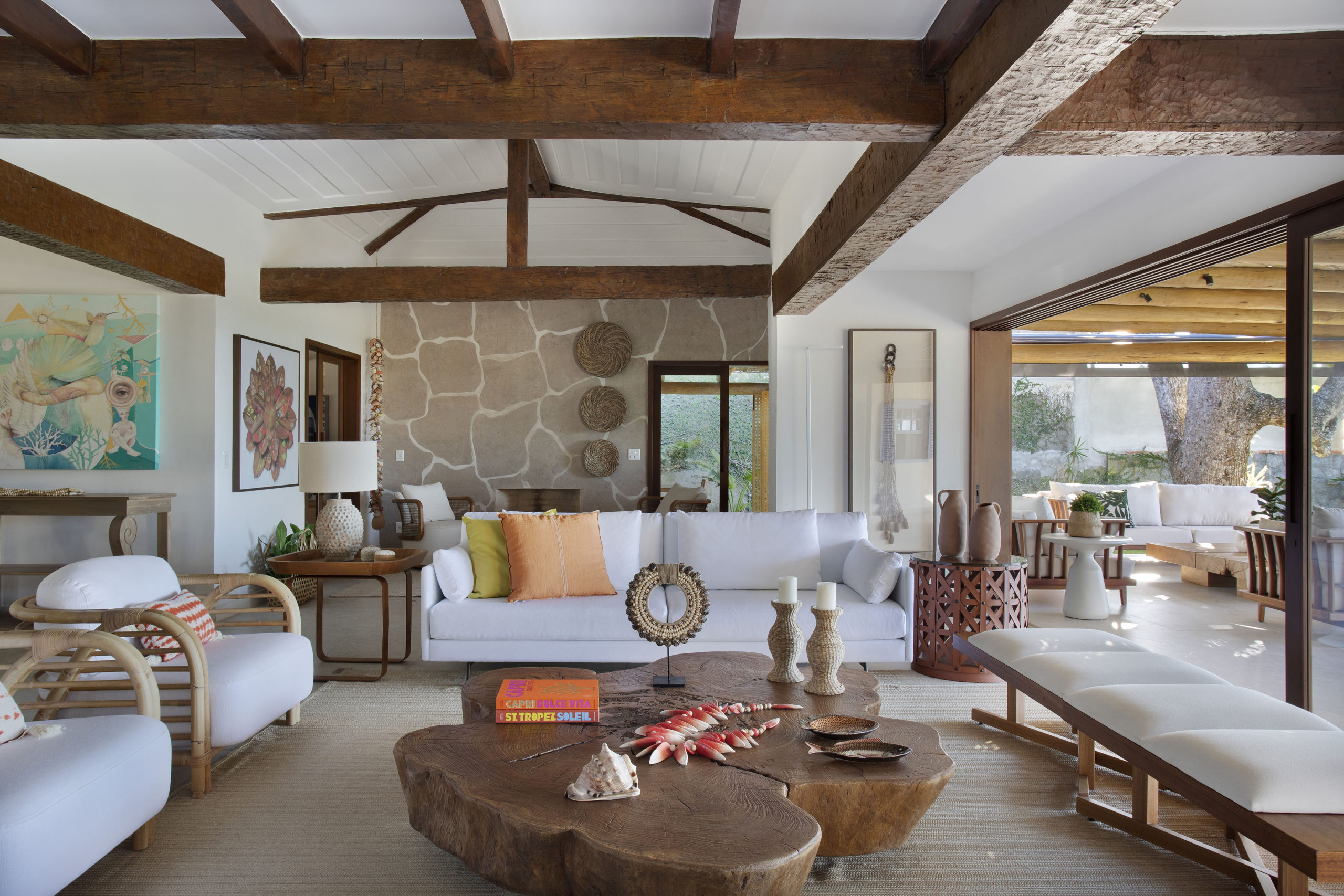 sala de casa de praia com sofá, mesa de centro de madeira com vigas de madeira no teto