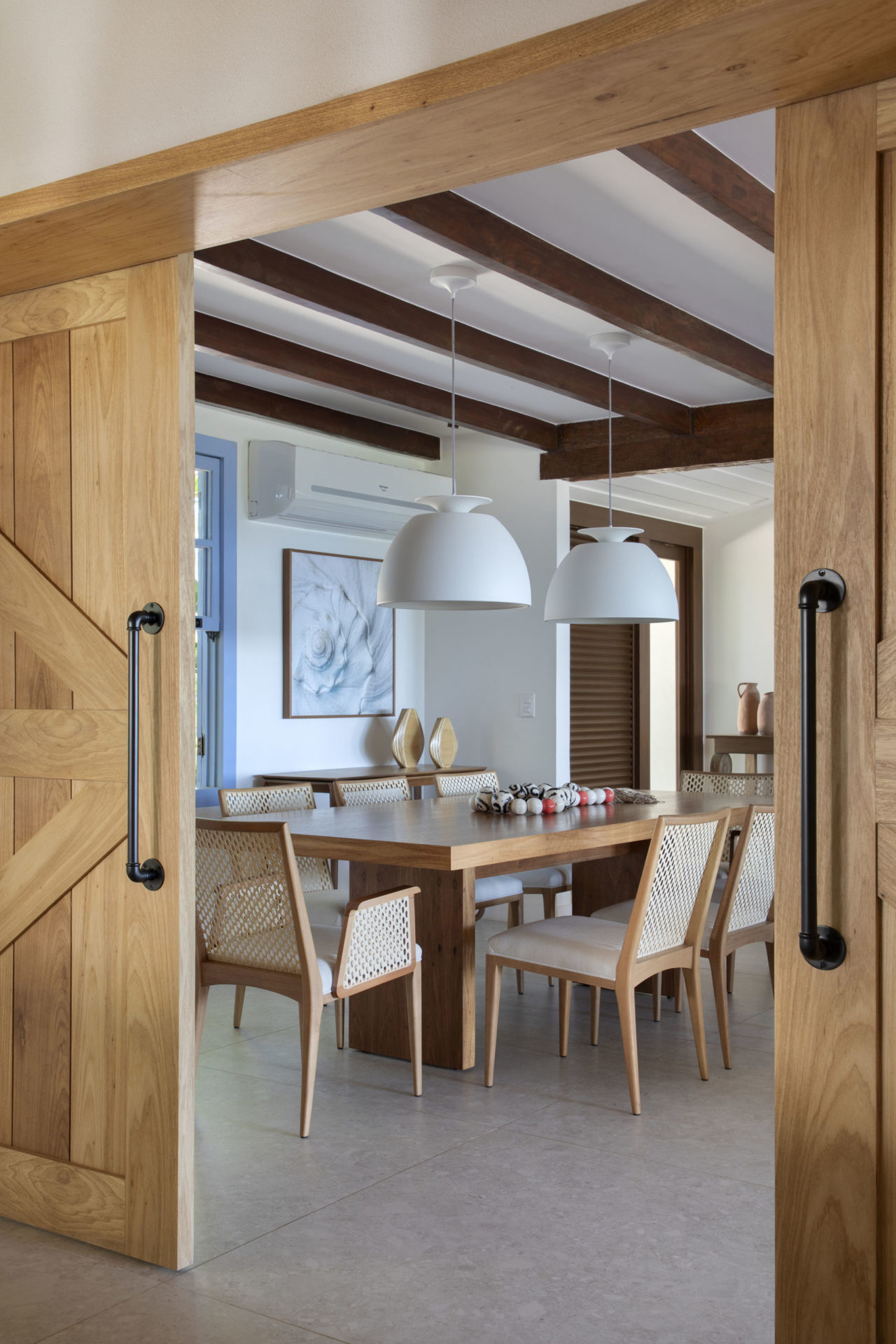 sala de jantar com mesa de jantar, luminária e porta de madeira
