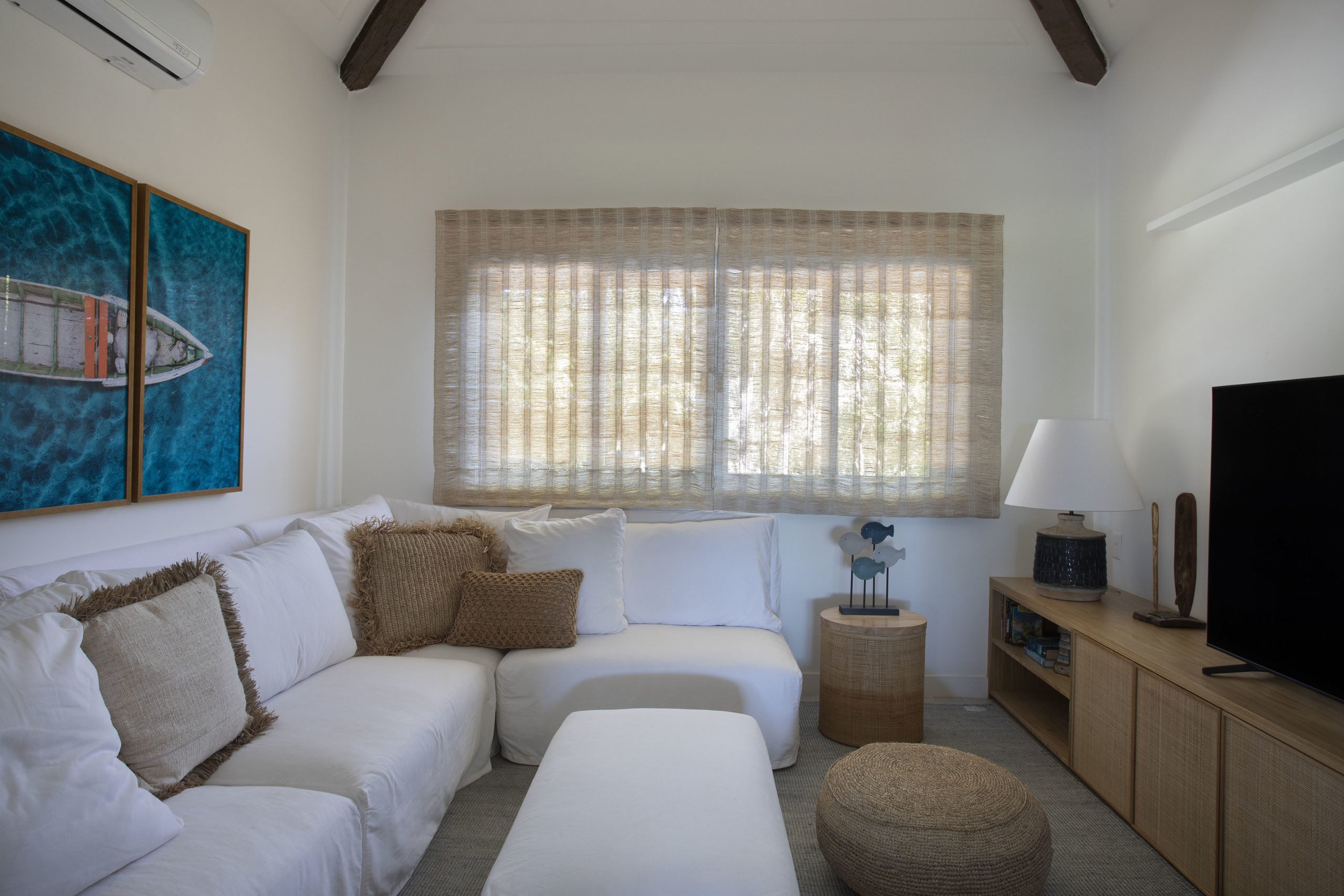 sala de televisão com sofá branco, janela