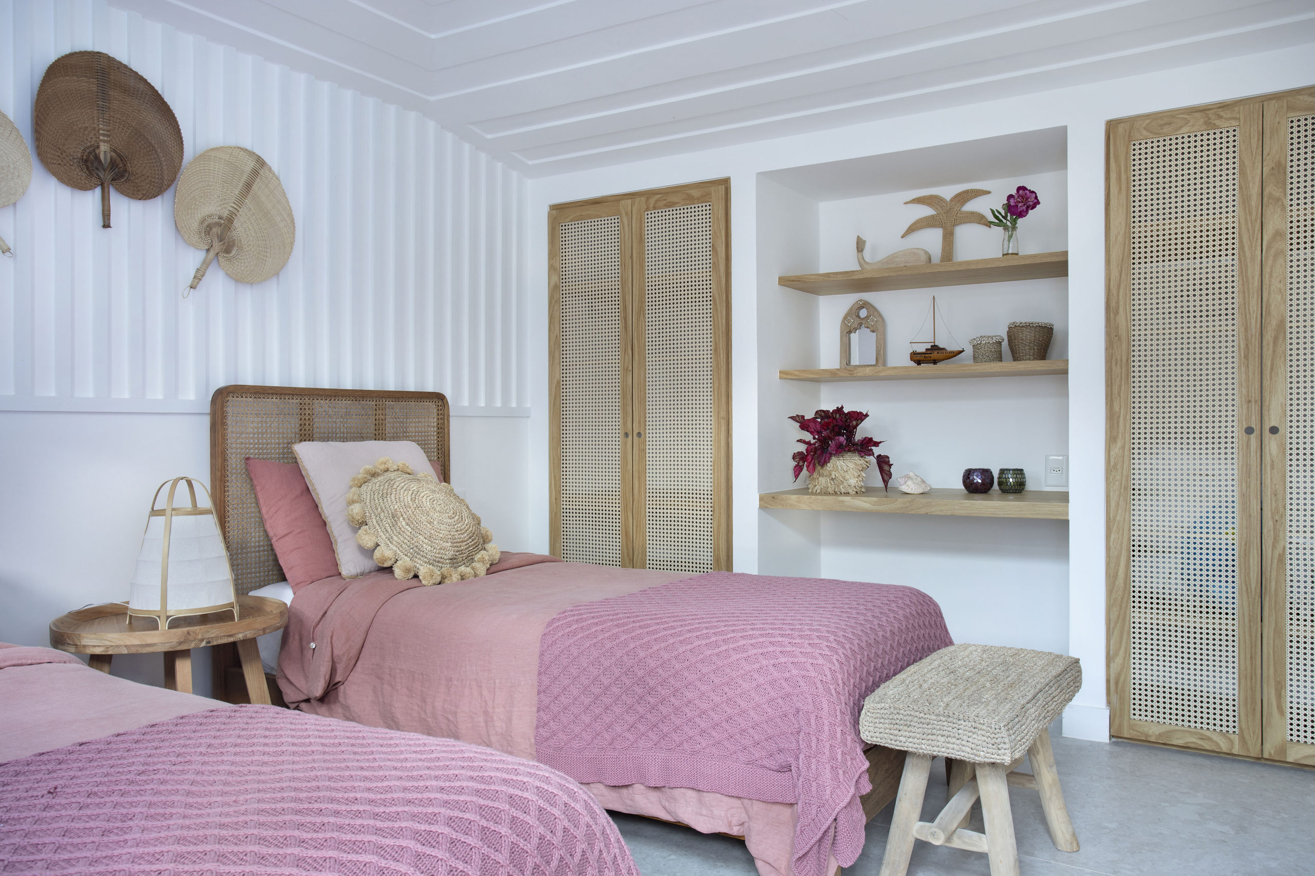 quarto com duas camas de solteiro e prateleiras na parede