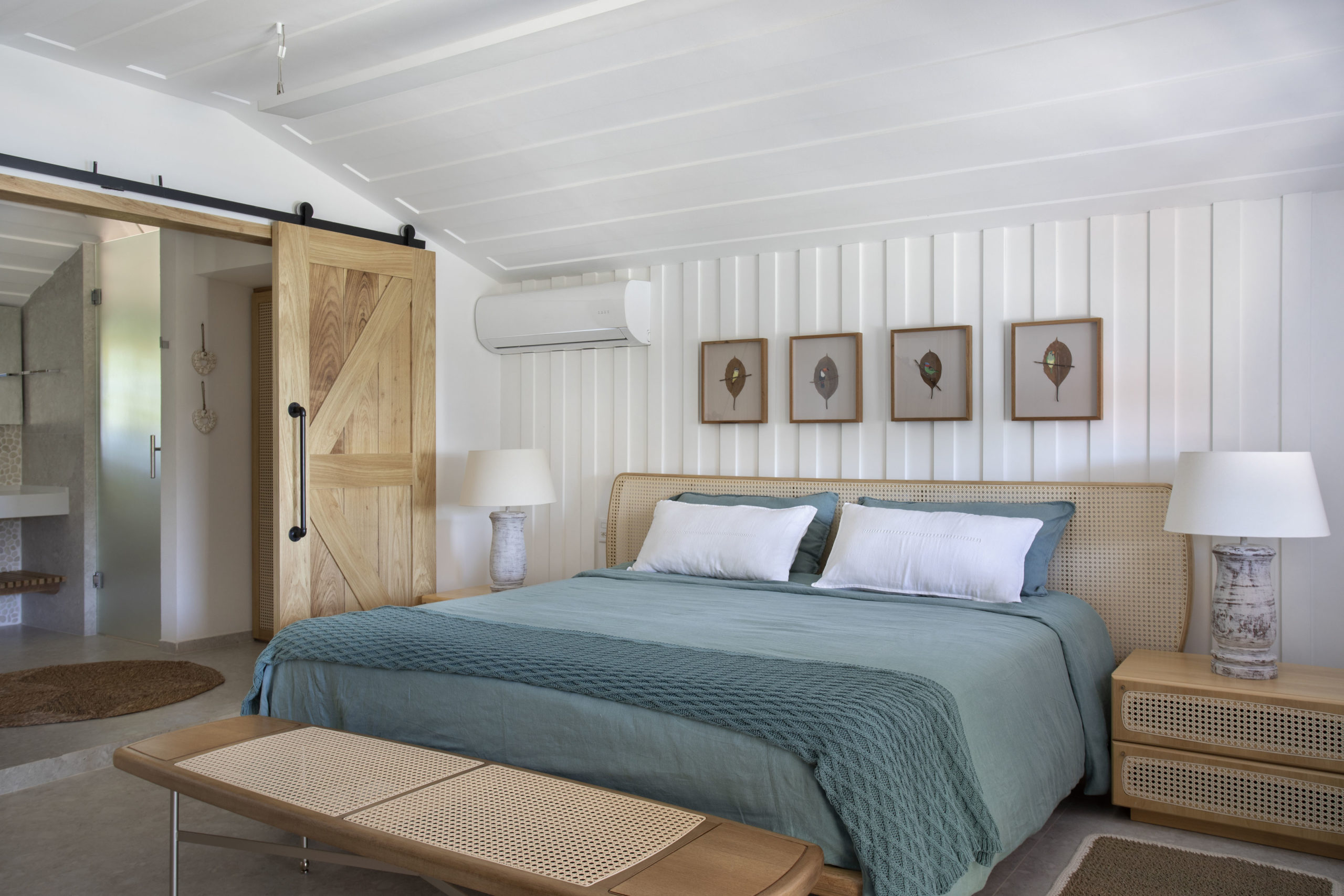 quarto com cama de casal e quatro quadros na parede