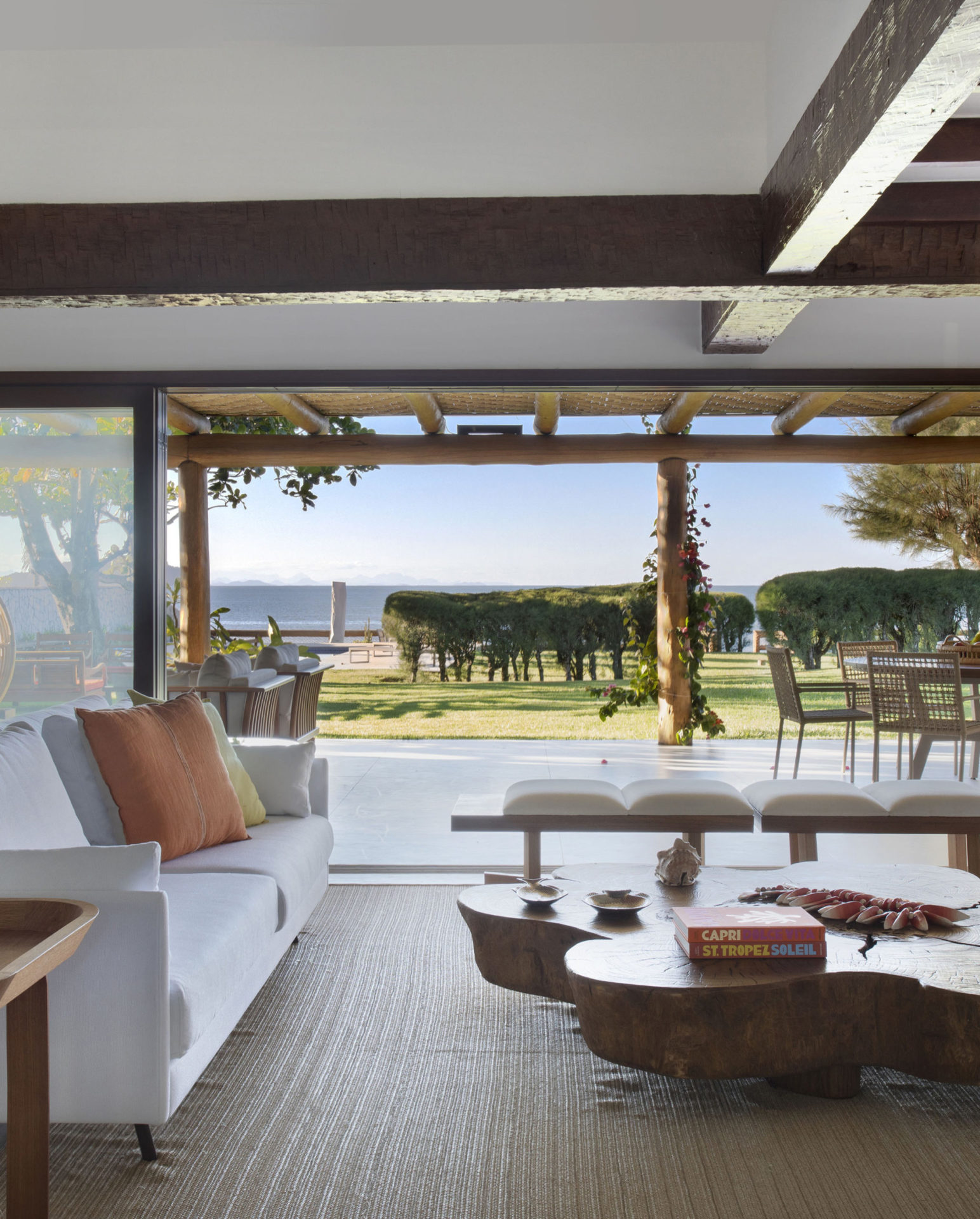 sala com mesa de centro, sofá branco e varanda