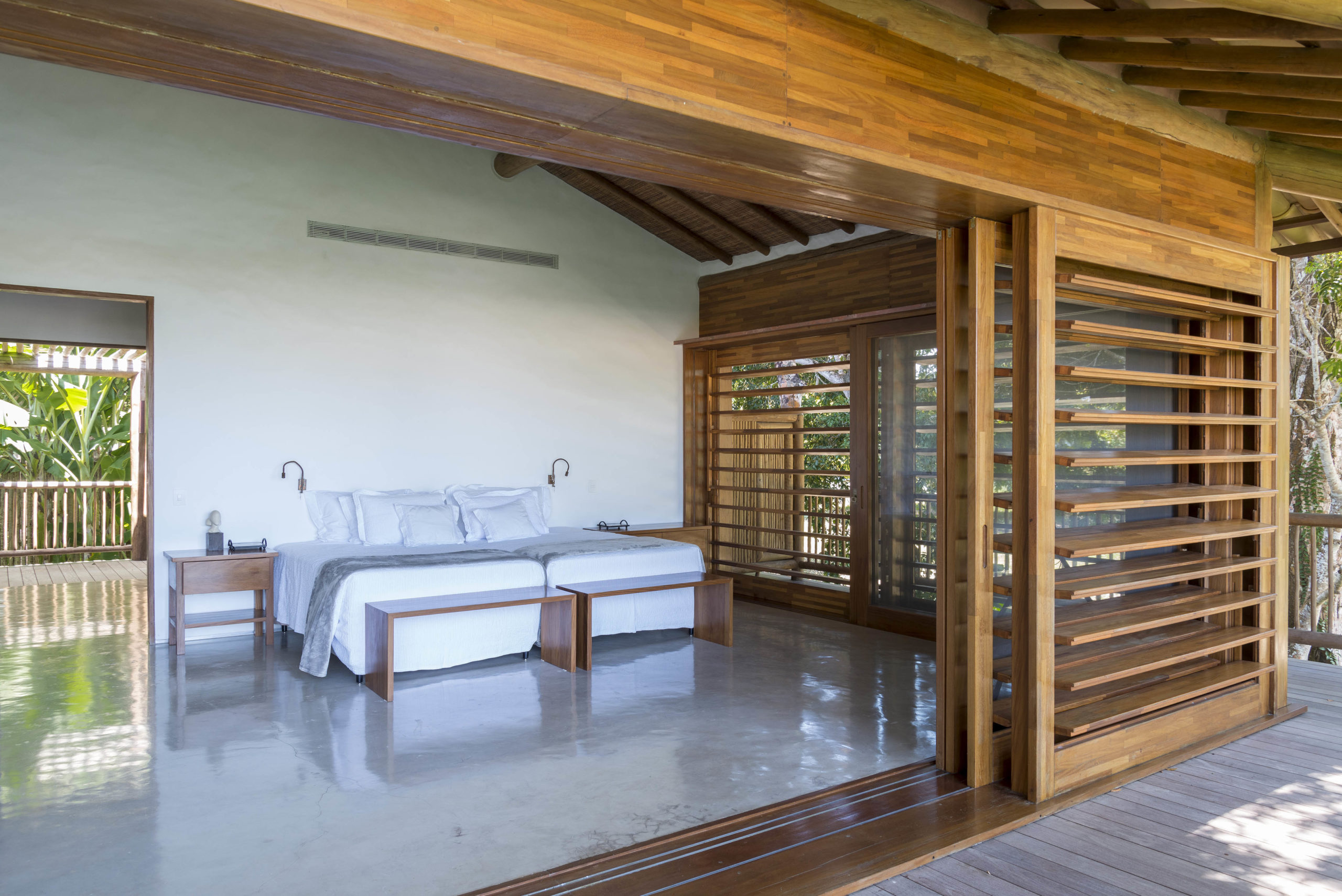 quarto com cama de casal com destaque para a madeira em todo o quarto