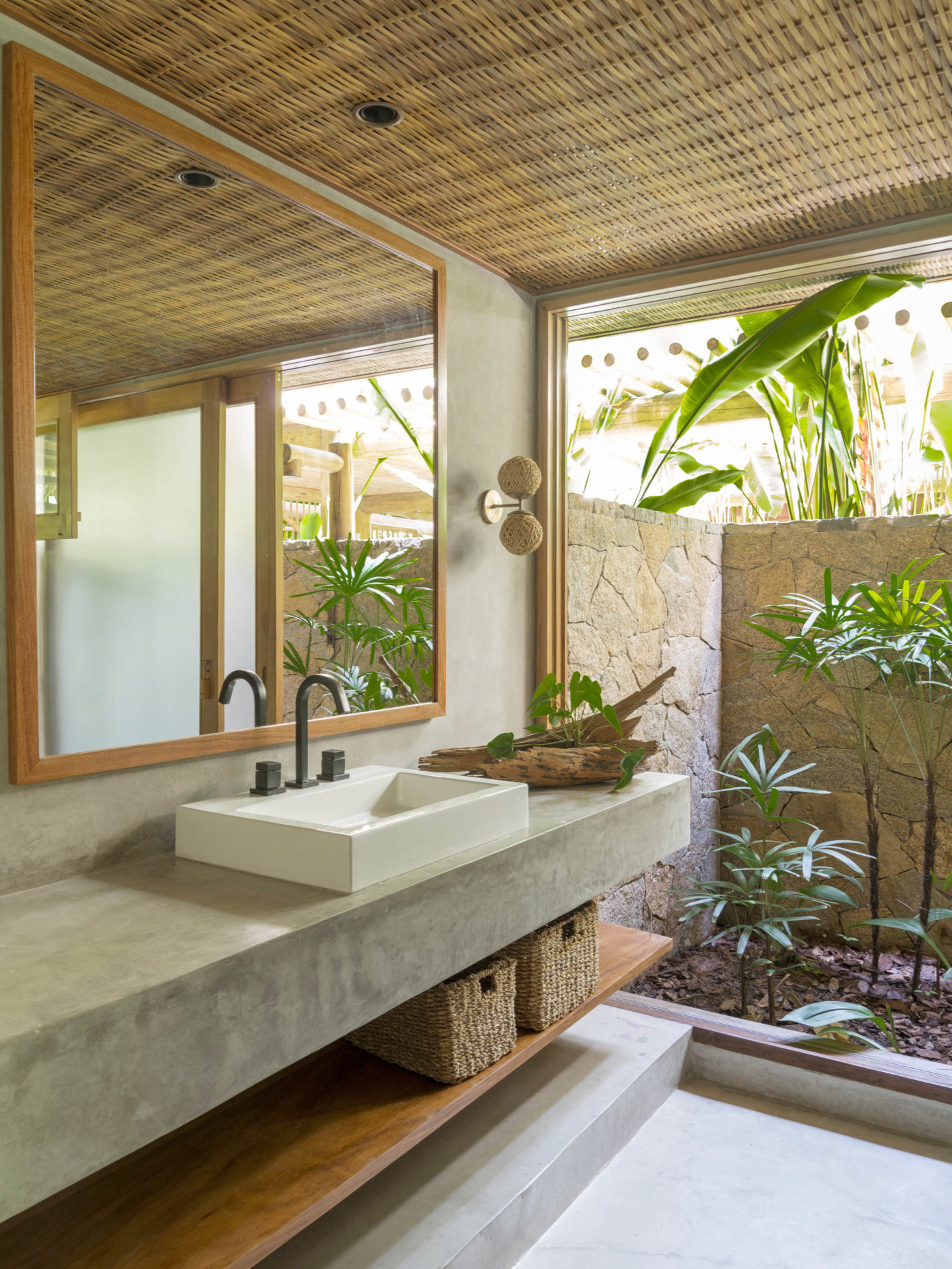 banheiro com plantas e grande espelho