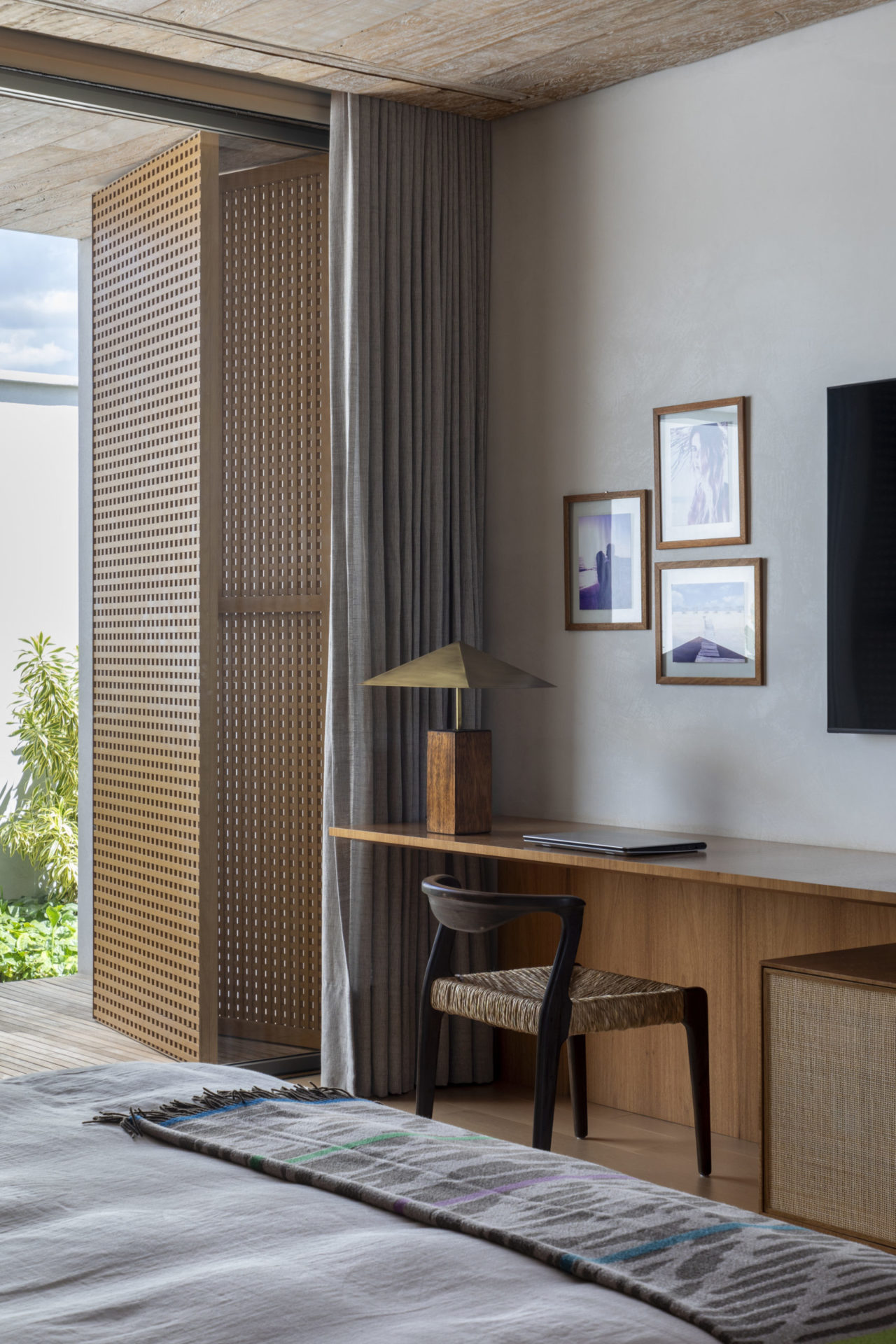 mesa de trabalho em quarto de casal e 3 quadros na parede