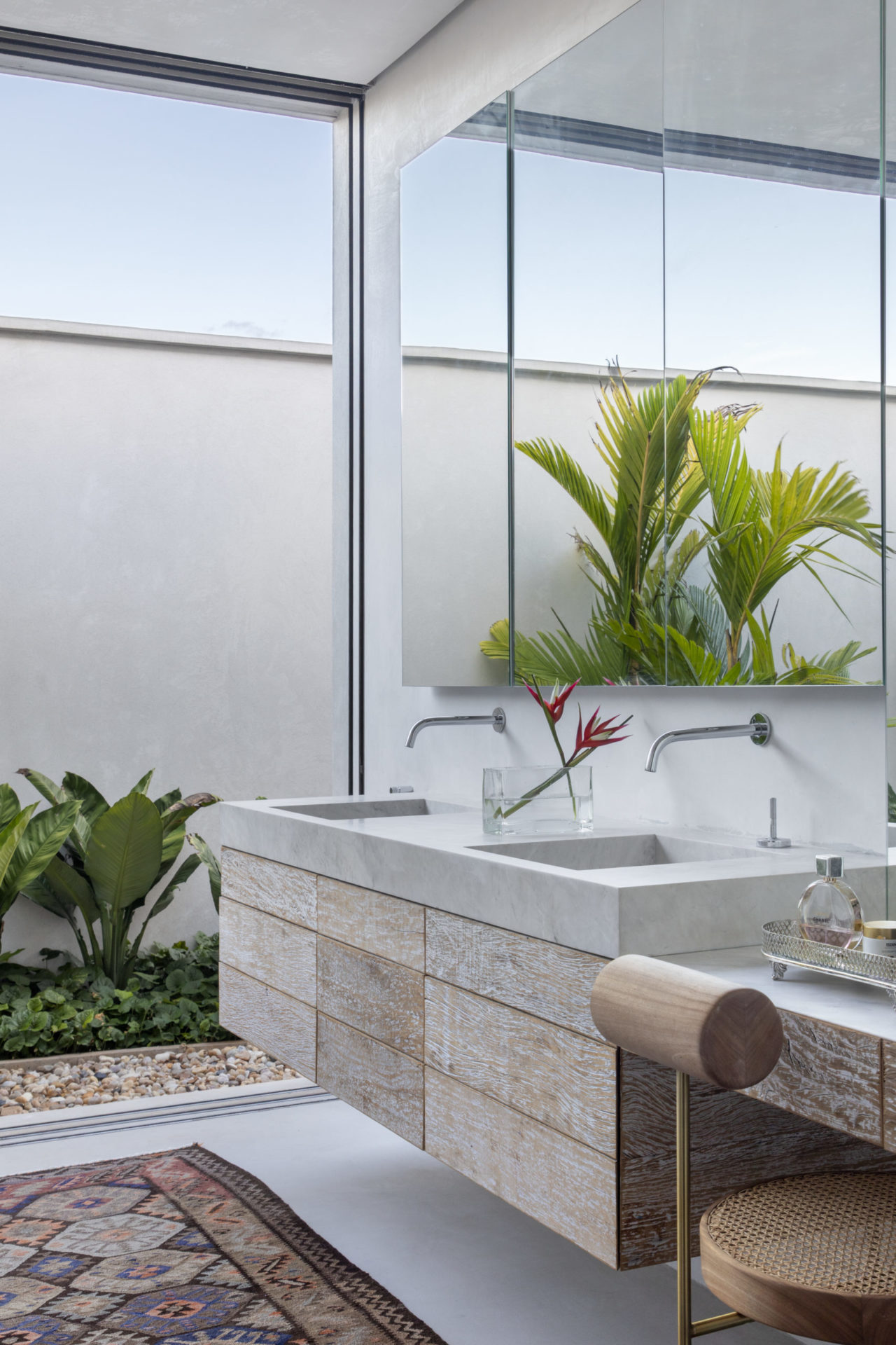 banheiro com espelho grande, plantas e bancada