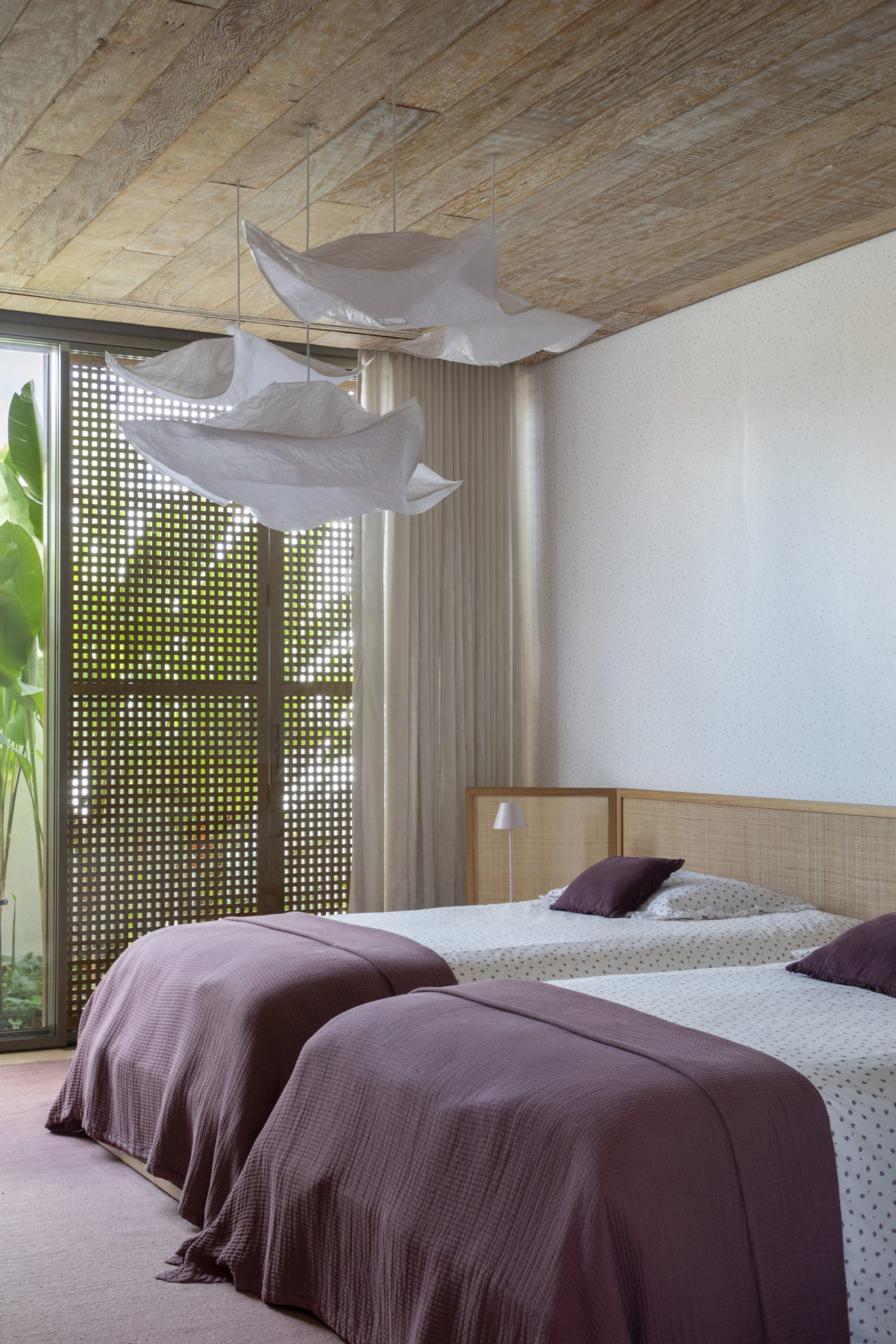 quarto com duas camas de solteiro e luminárias