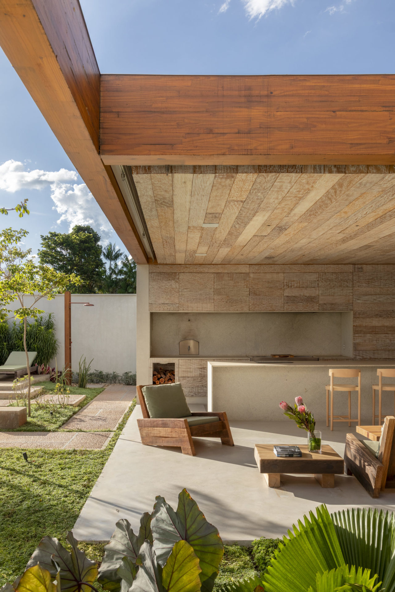 área externa da casa térrea com uso de madeira em móveis e estrutura
