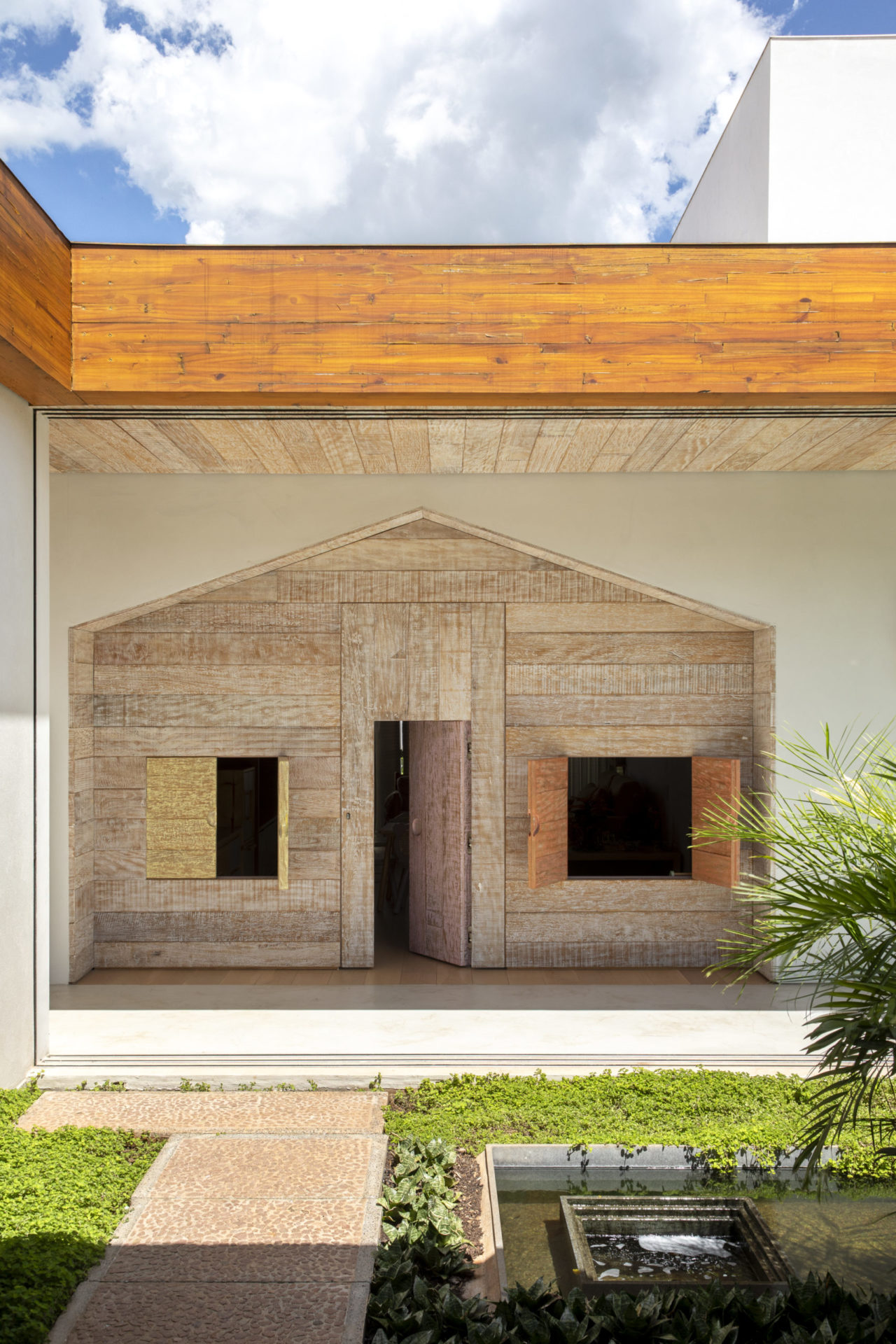 casa com uma porta e duas janelas que prioriza linhas retas em sua área externa e jardim na frente
