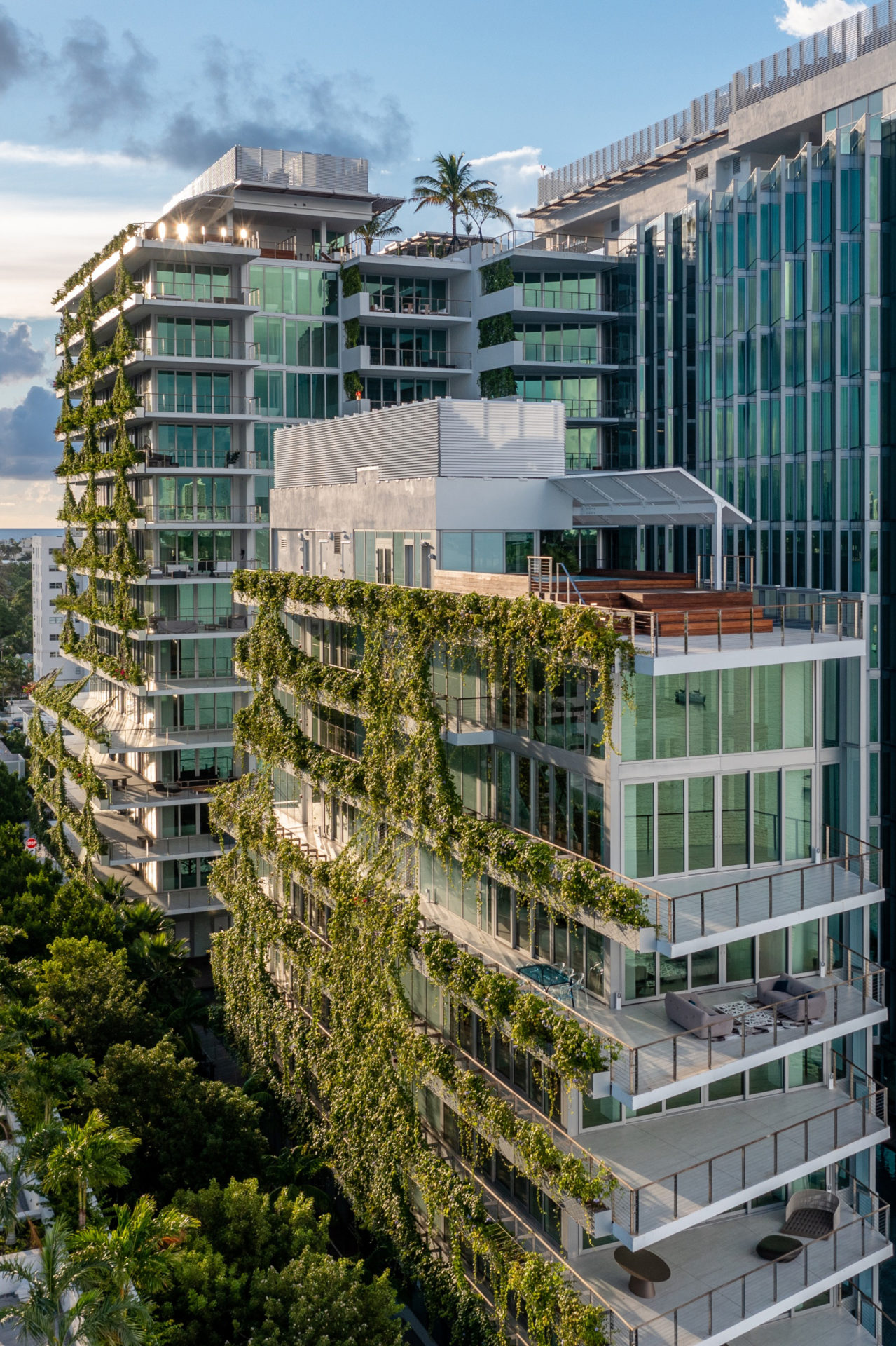 vista externa de prédio com varandas e plantas nas varandas