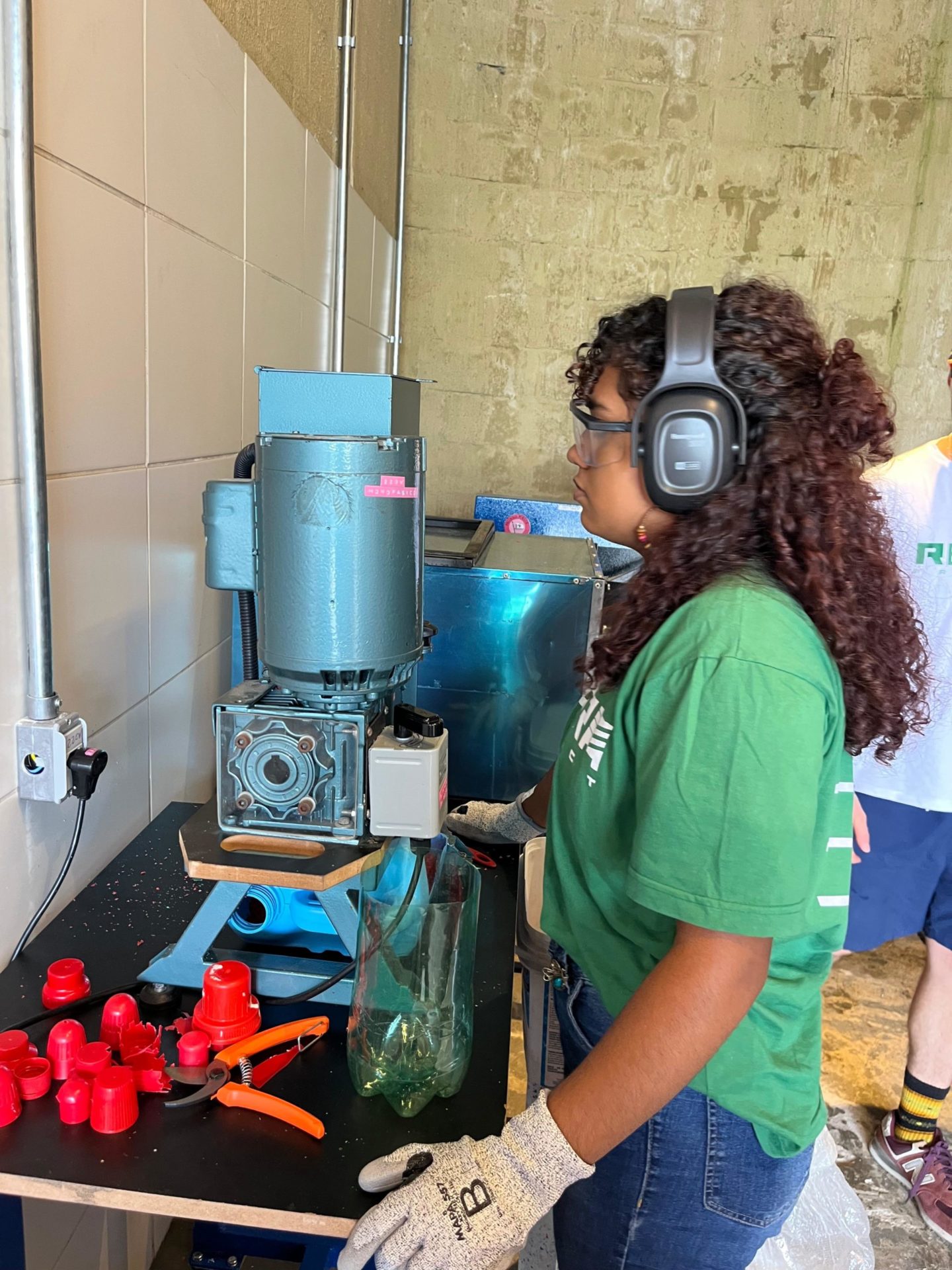 mulher de cabelo comprido, com fone de ouvido em frente a uma máquina