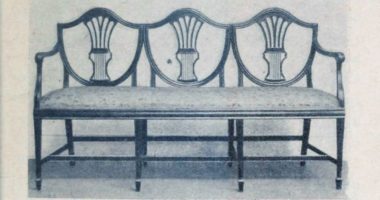 móvel com estofado para três lugares que lembra um sofá