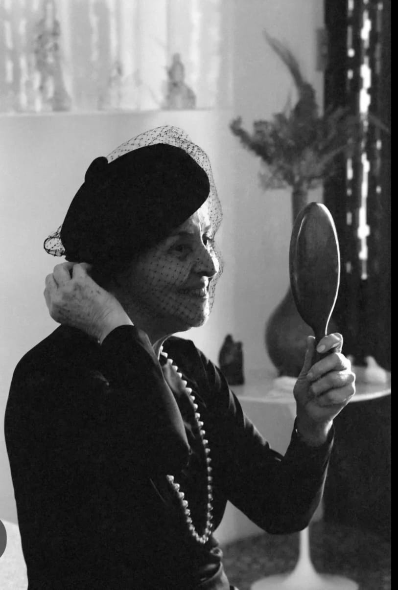 foto em preto e branco de uma mulher com chapéu preto e vestido preto