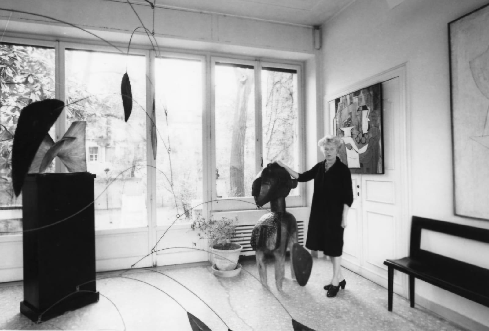 fotografia em preto e branco com uma mulher branca e loira e obras de arte