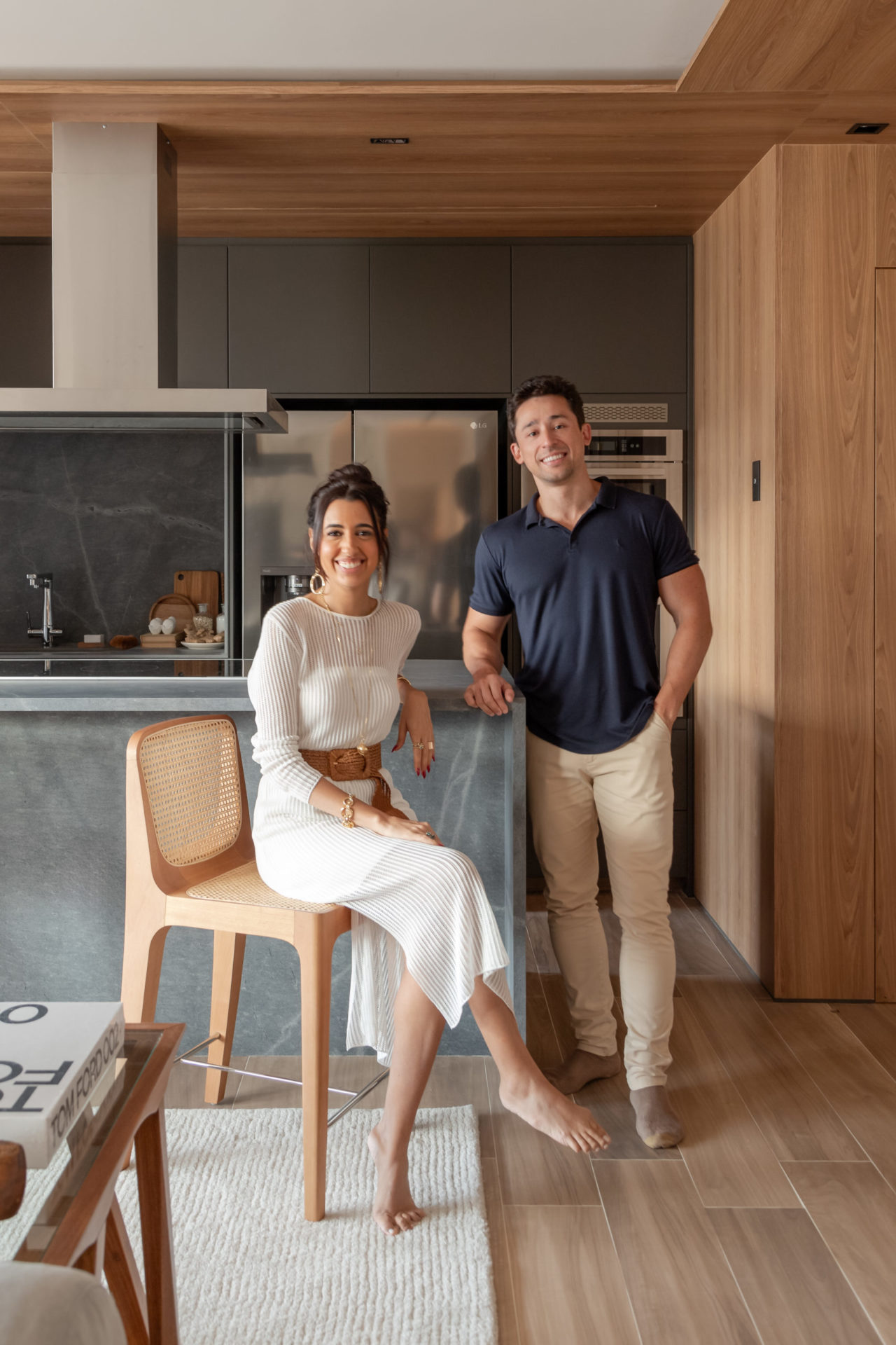 na foto uma mulher vestida de branco sentada e um homem branco em pé