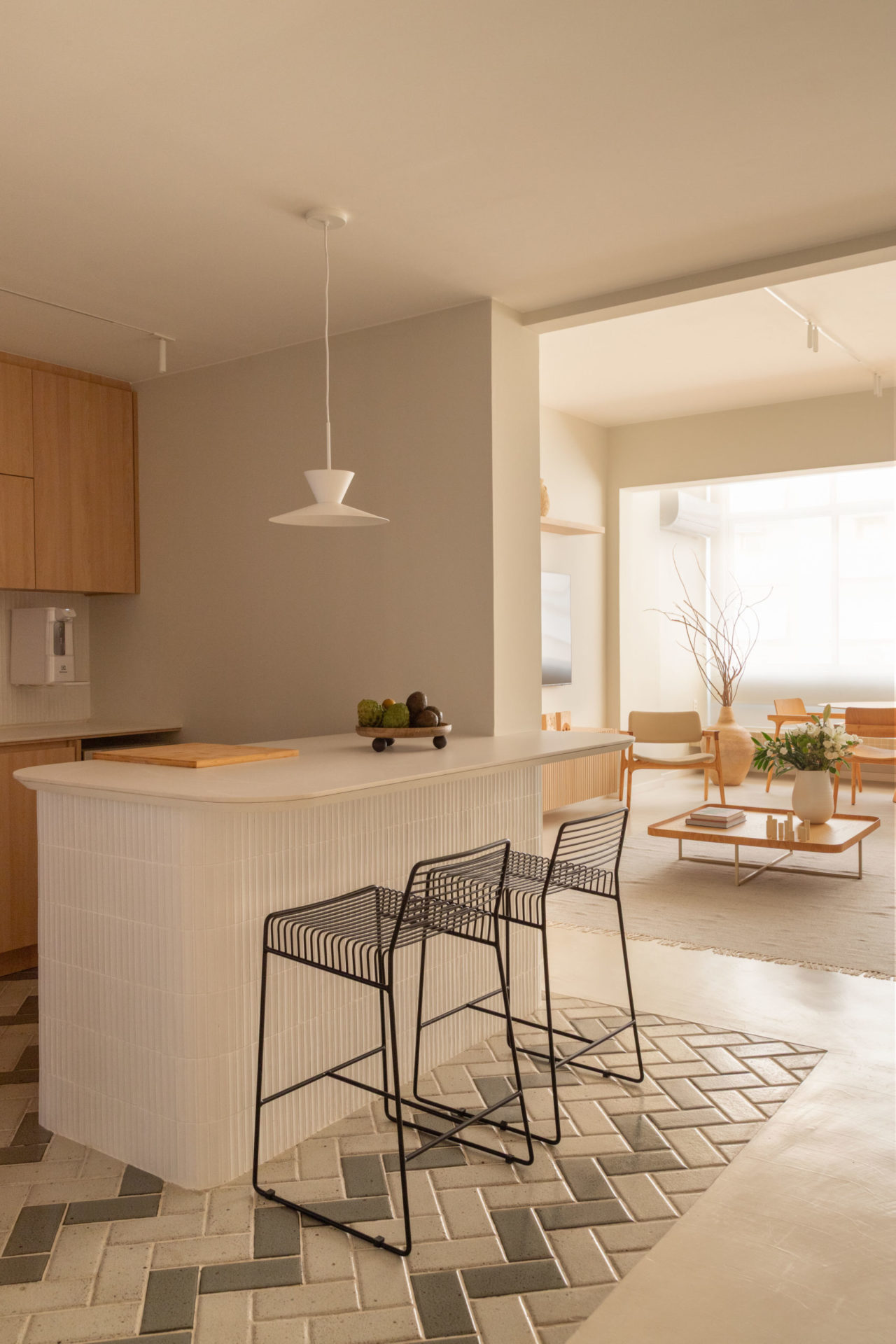 na foto cozinha com abertura para a sala de estar, ambas em tons claros