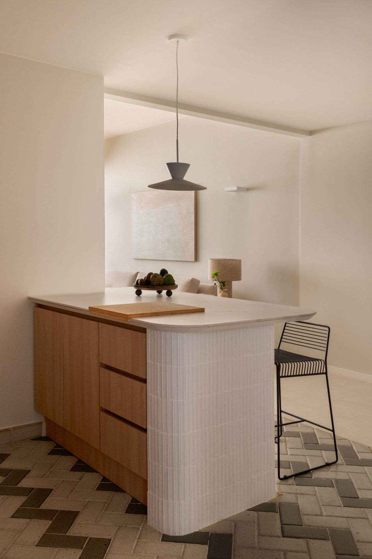 na foto bancada branca da cozinha com banquetas pretas