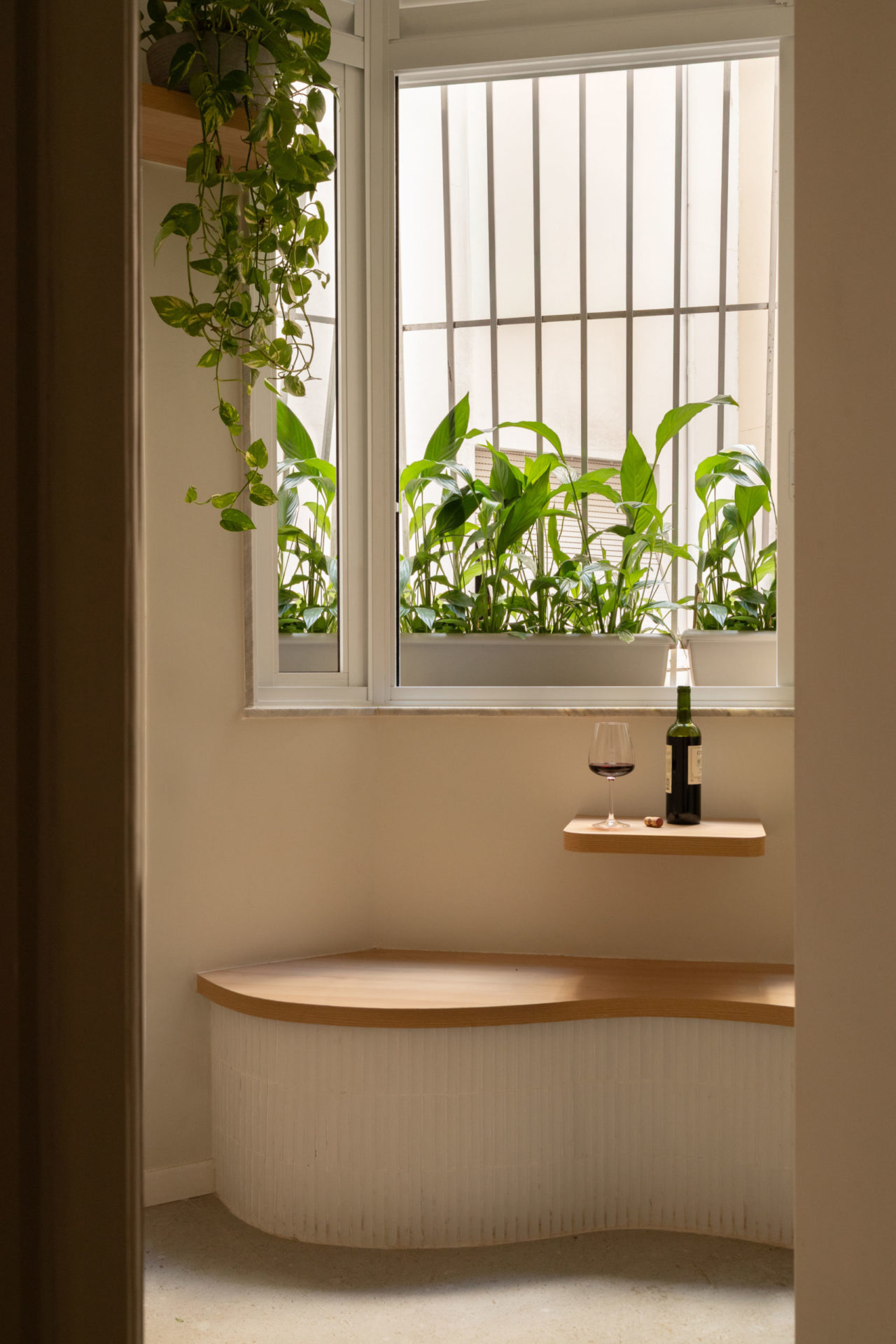 na foto espaço para apreciação de vinho com um banco de madeira e janela