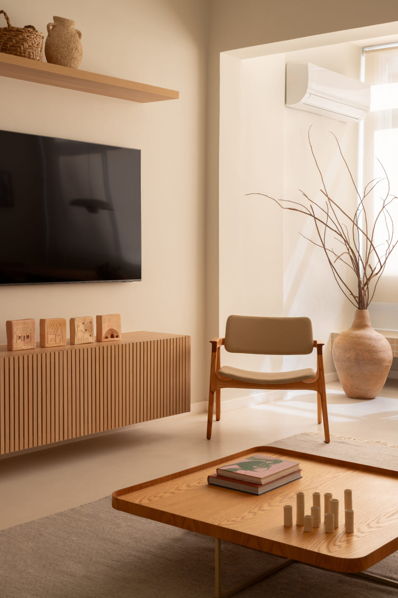 na fotosala de estar com mesa de centro de madeira clara, rack e tv