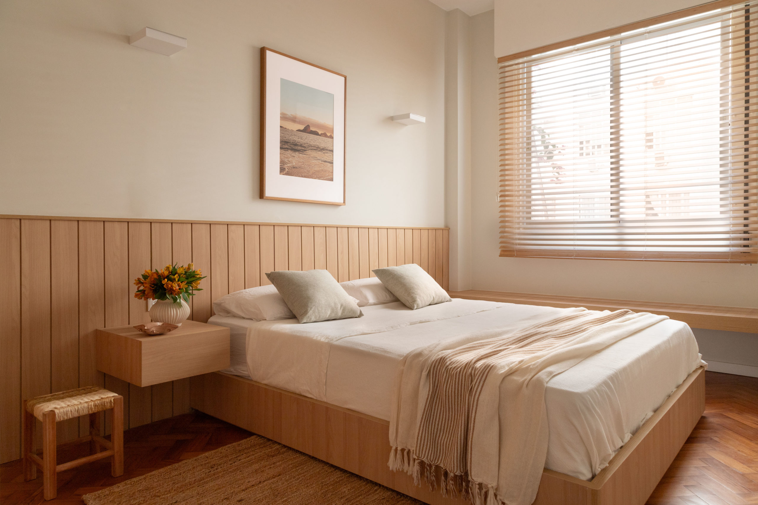 na foto quarto com cama de casal, mesa de cabeceira e janela