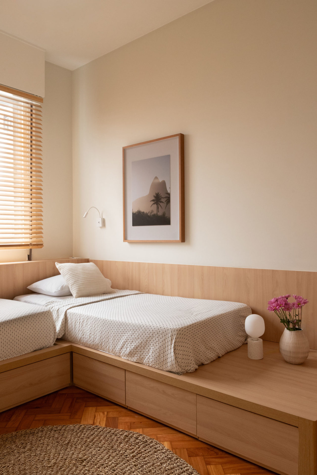 na foto quarto com duas camas, vasinho com flores e taco restaurado 
