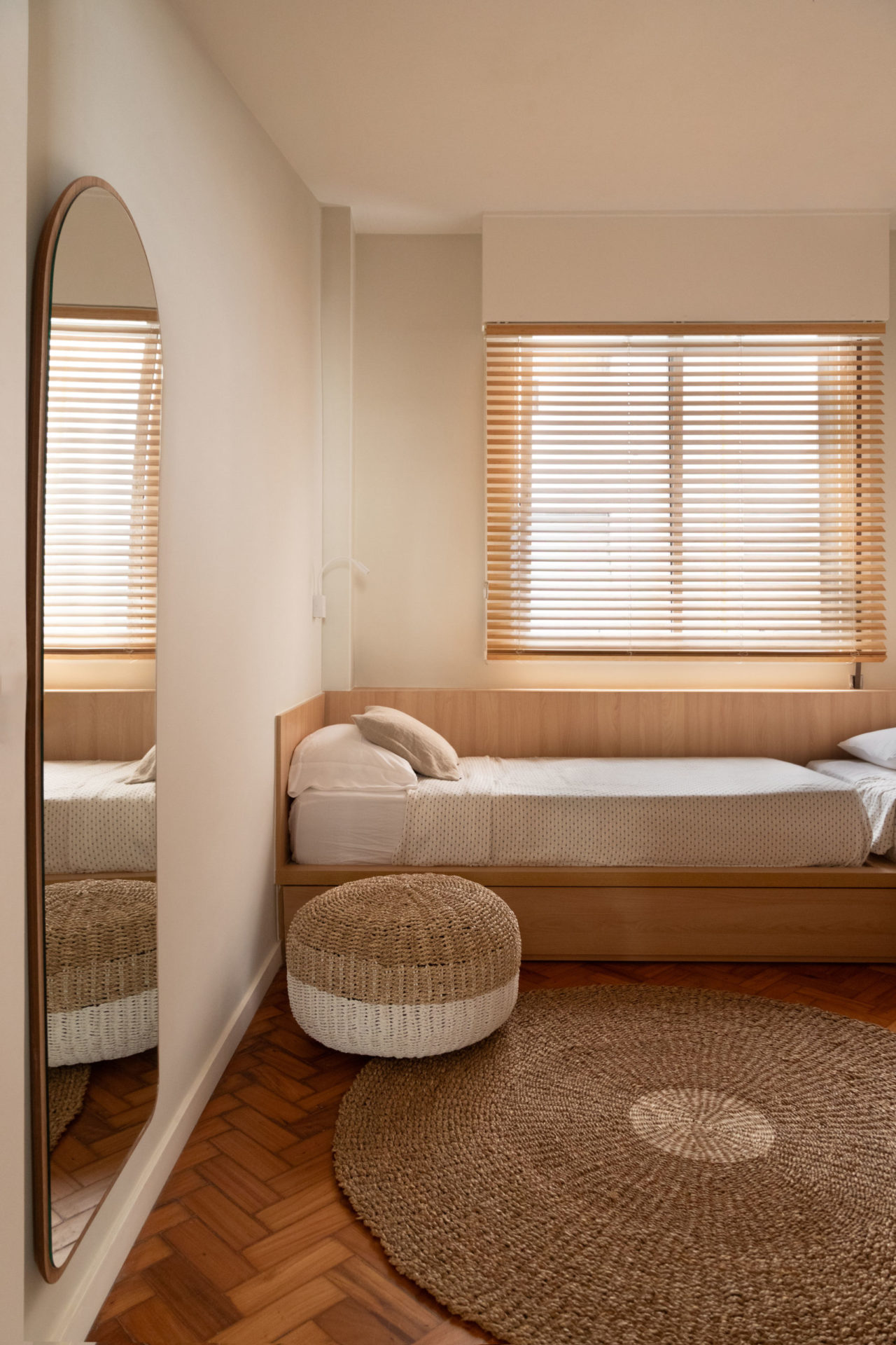na foto quarto de solteiro com espelho, um puff em tons claros e relaxantes