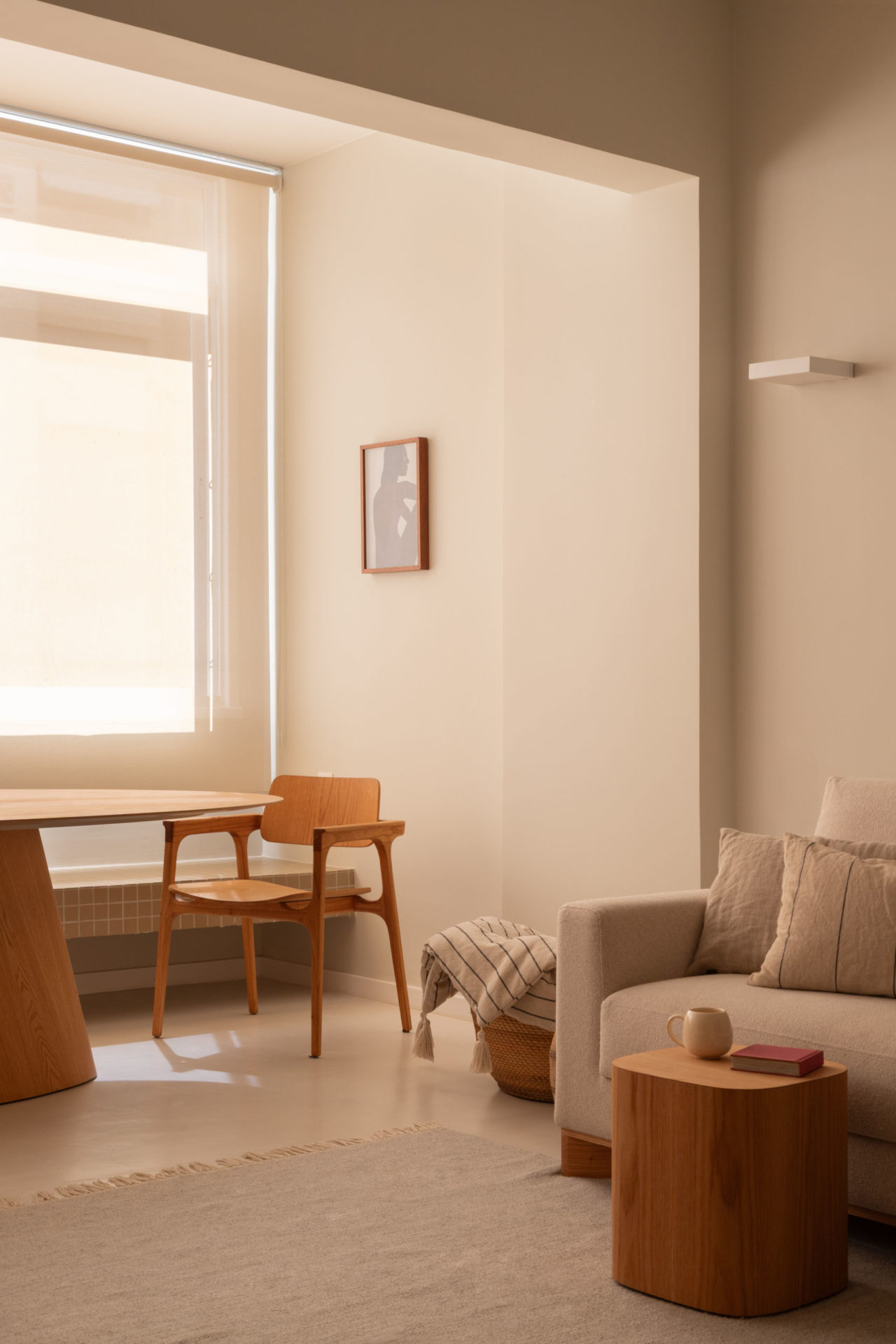 sala com paredes brancas, sofá, mesa de madeira