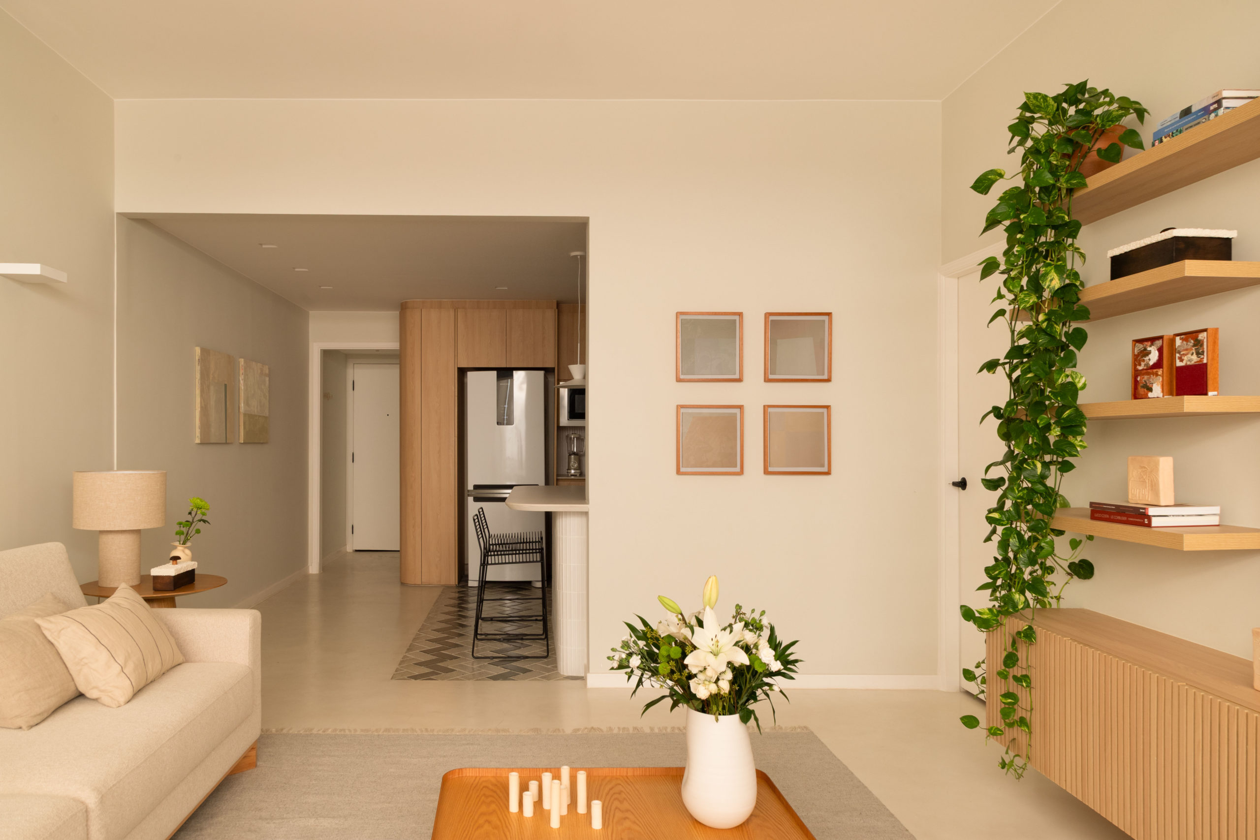 na foto sala de estar em tons claros e relaxantes e cozinha