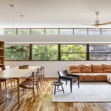 na foto uma sala de janela grande, mesa de jantar, sofá, poltrona