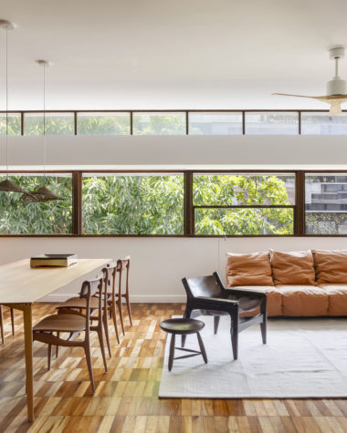 na foto uma sala de janela grande, mesa de jantar, sofá, poltrona