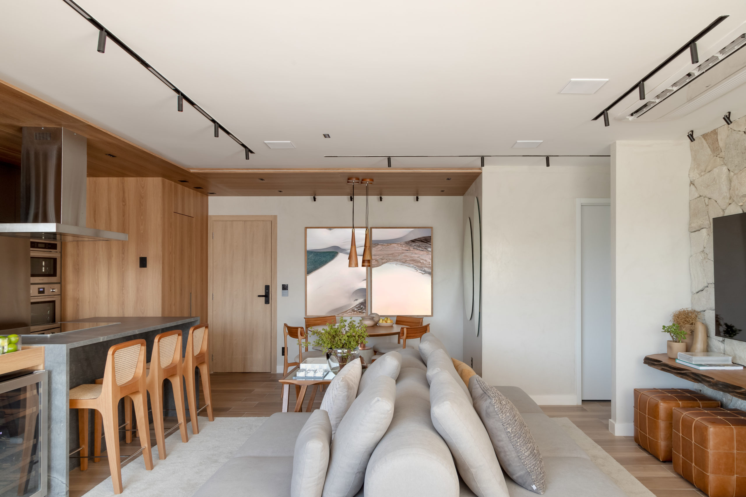 na foto sala com sofá em ilha, tv, quadros na parede 