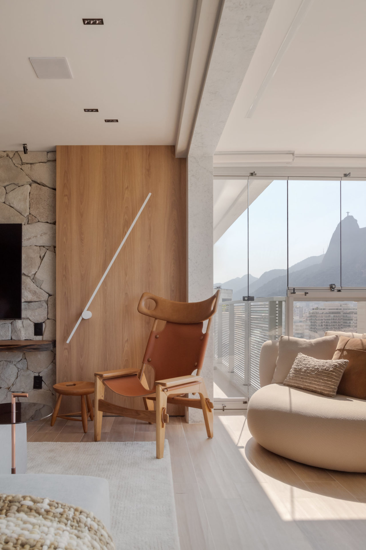 na foto poltrona Xibô, de Sergio Rodrigues, uma varanda e um sofá
