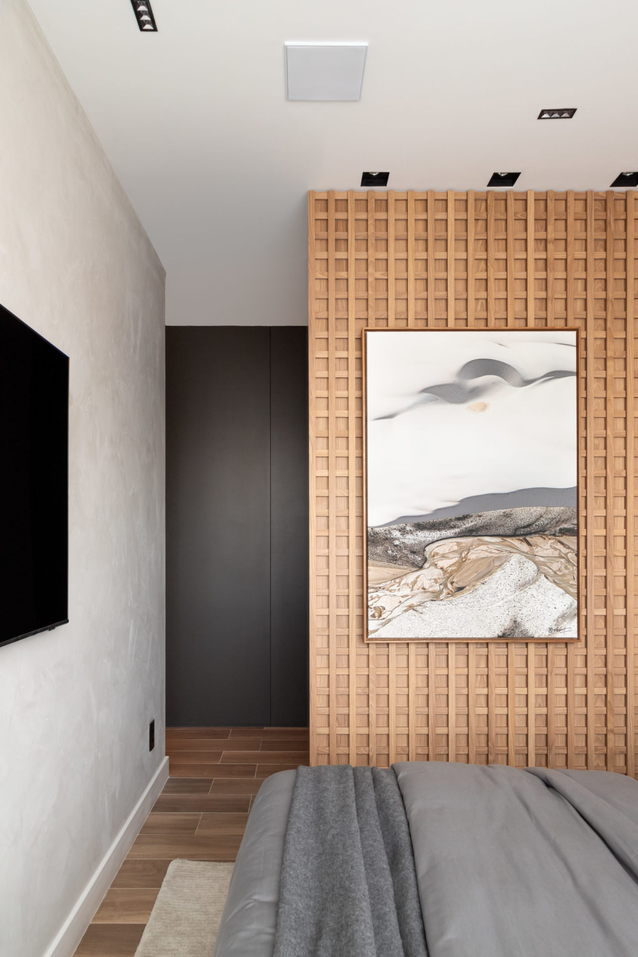 na foto quarto com cama, um quadro e uma TV na parede