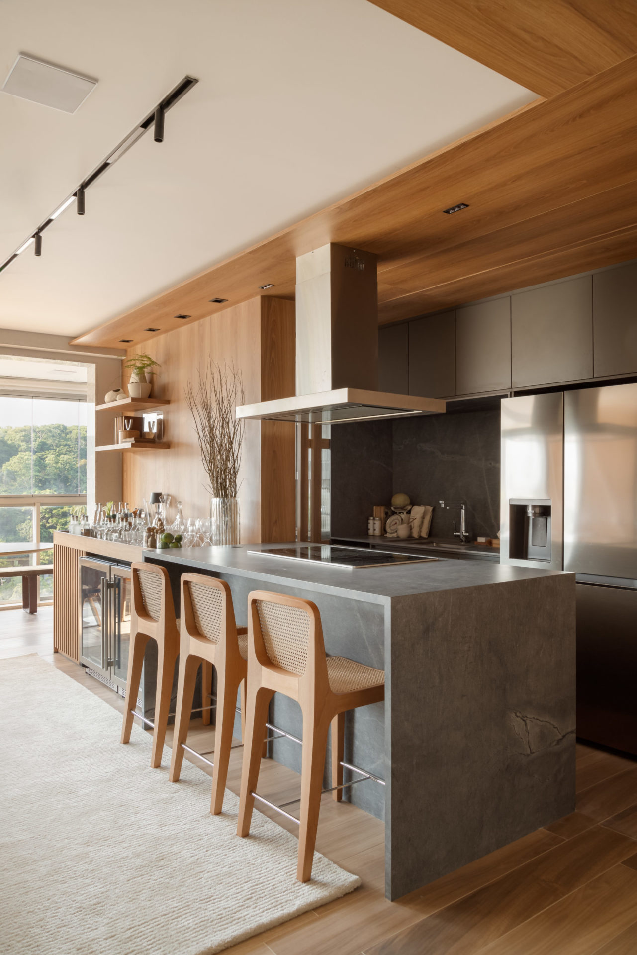 na foto cozinha de apartamento reformado com banquetas, bancada e janela