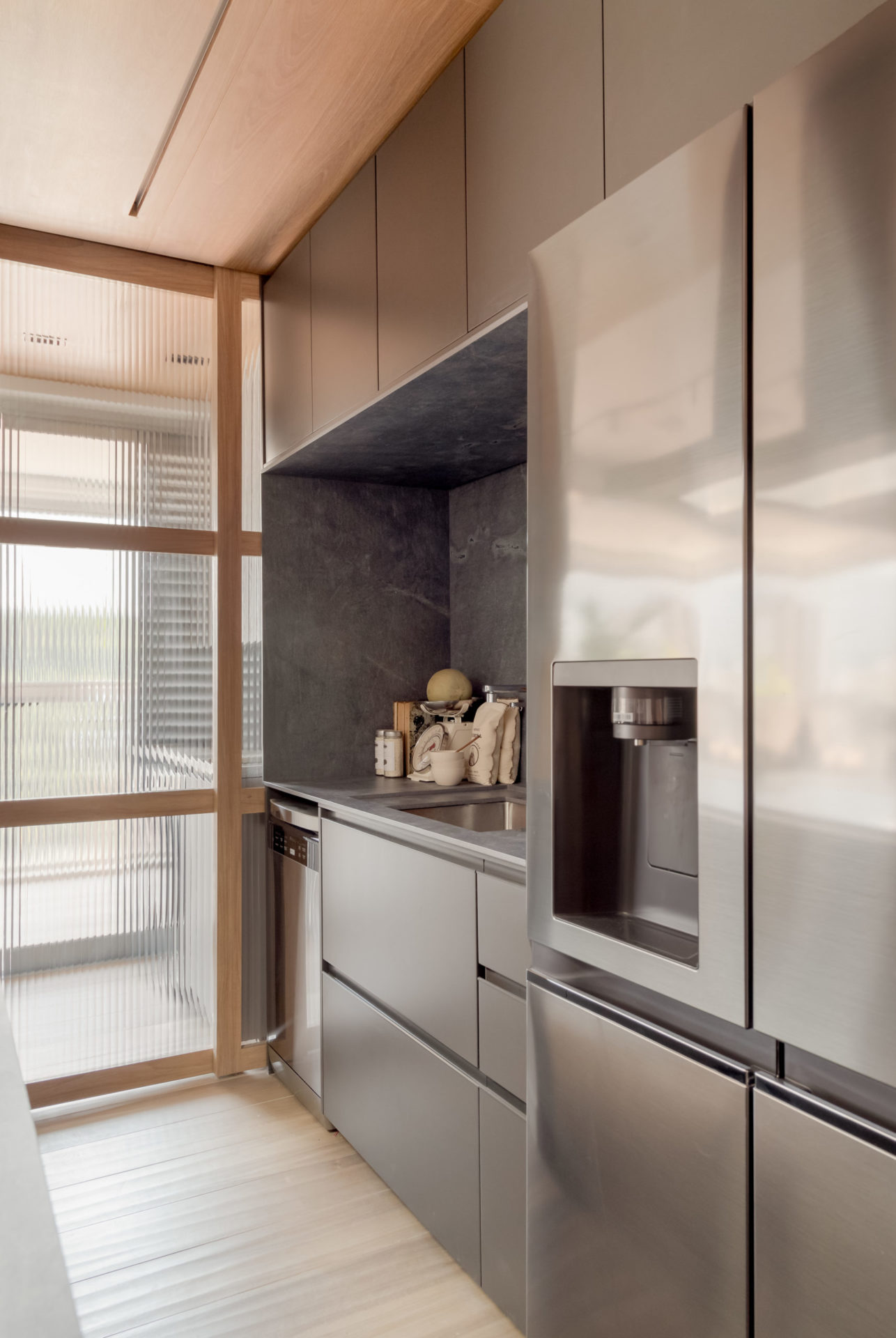 na foto cozinha com geladeira e armário em tons de cinza