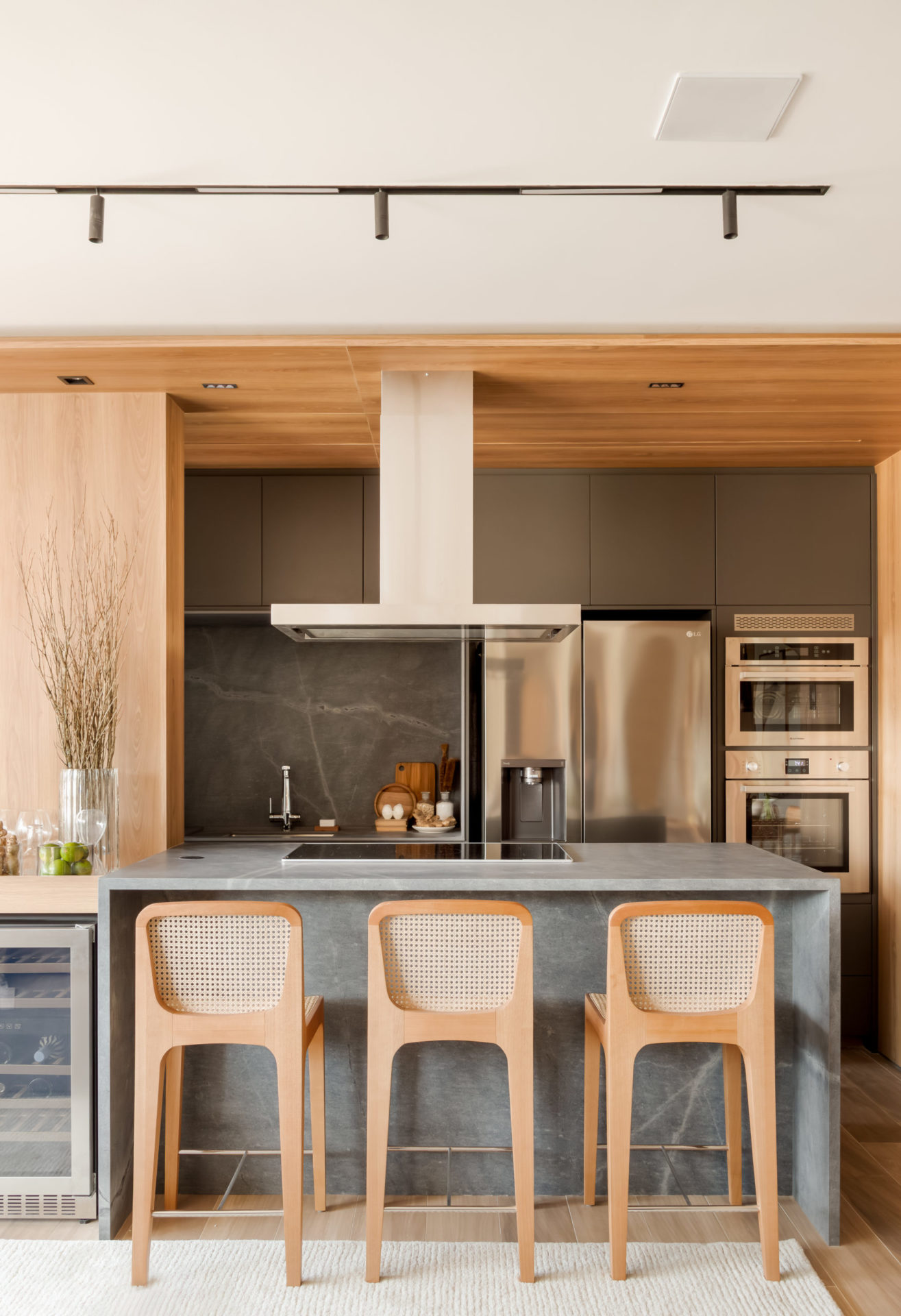 na foto bancada da cozinha com banquetas de madeira