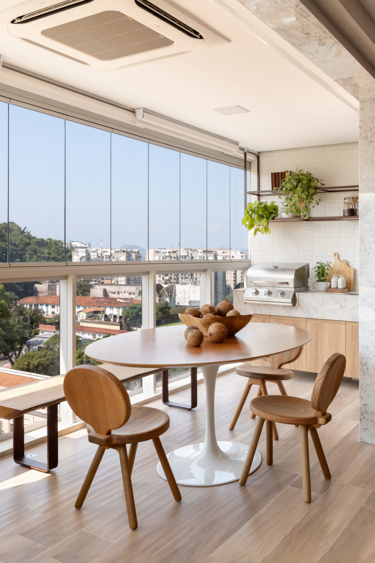 na foto uma mesa com cadeiras Pivete, do estúdio Mula Preta e varanda