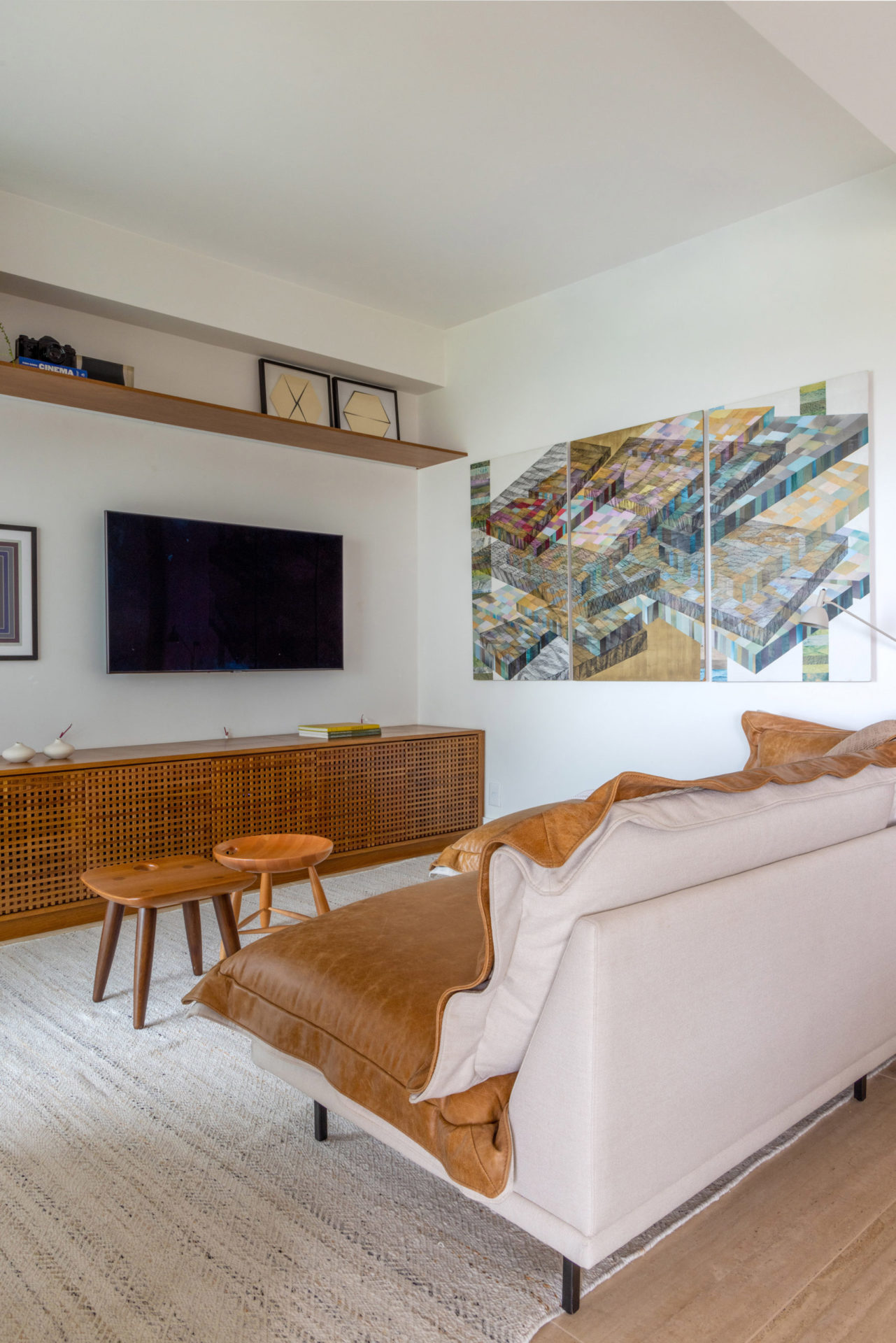 na foto sala com televisão, sofá e móveis de madeira