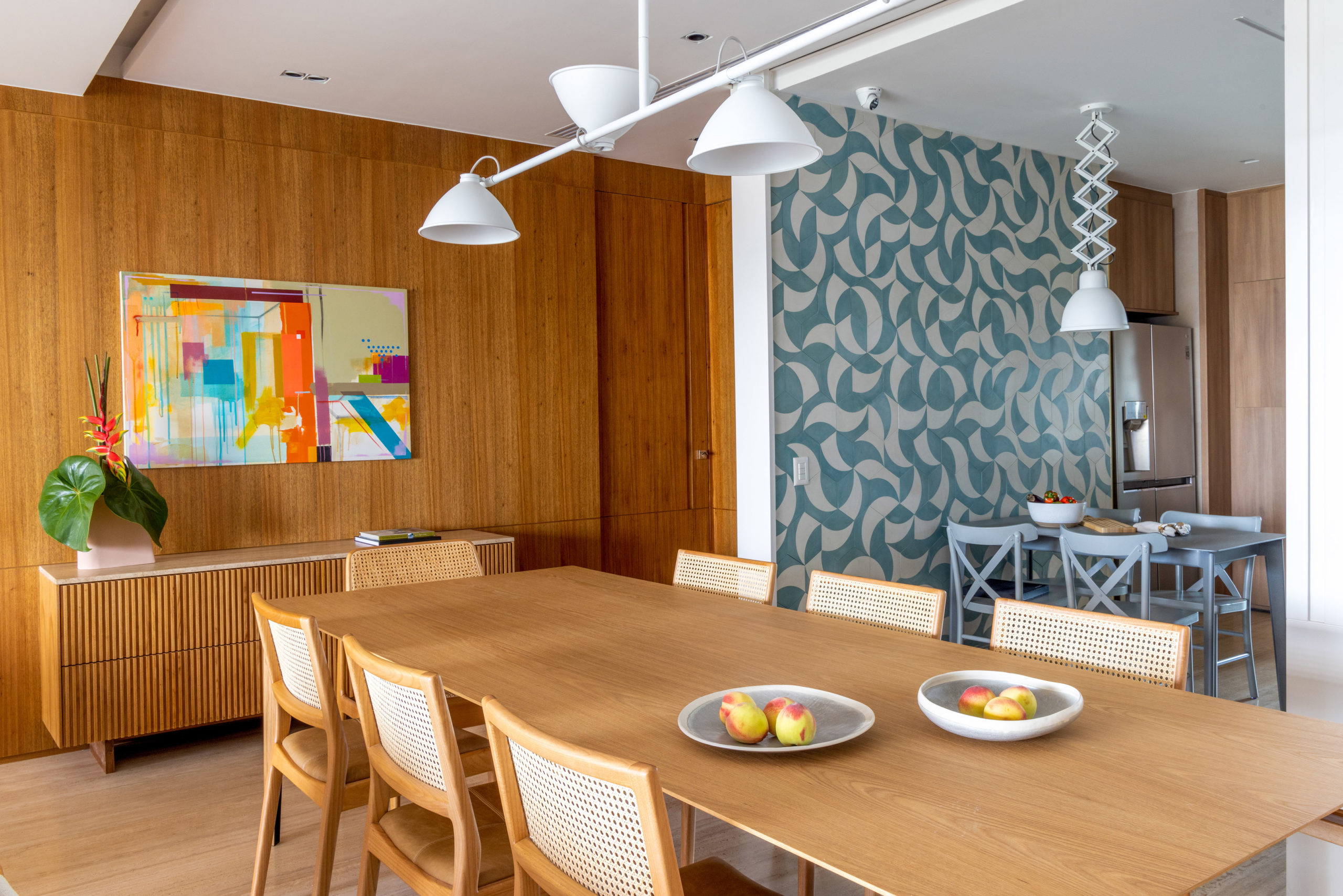 na foto sala de jantar com luminária branca e quadro na parede