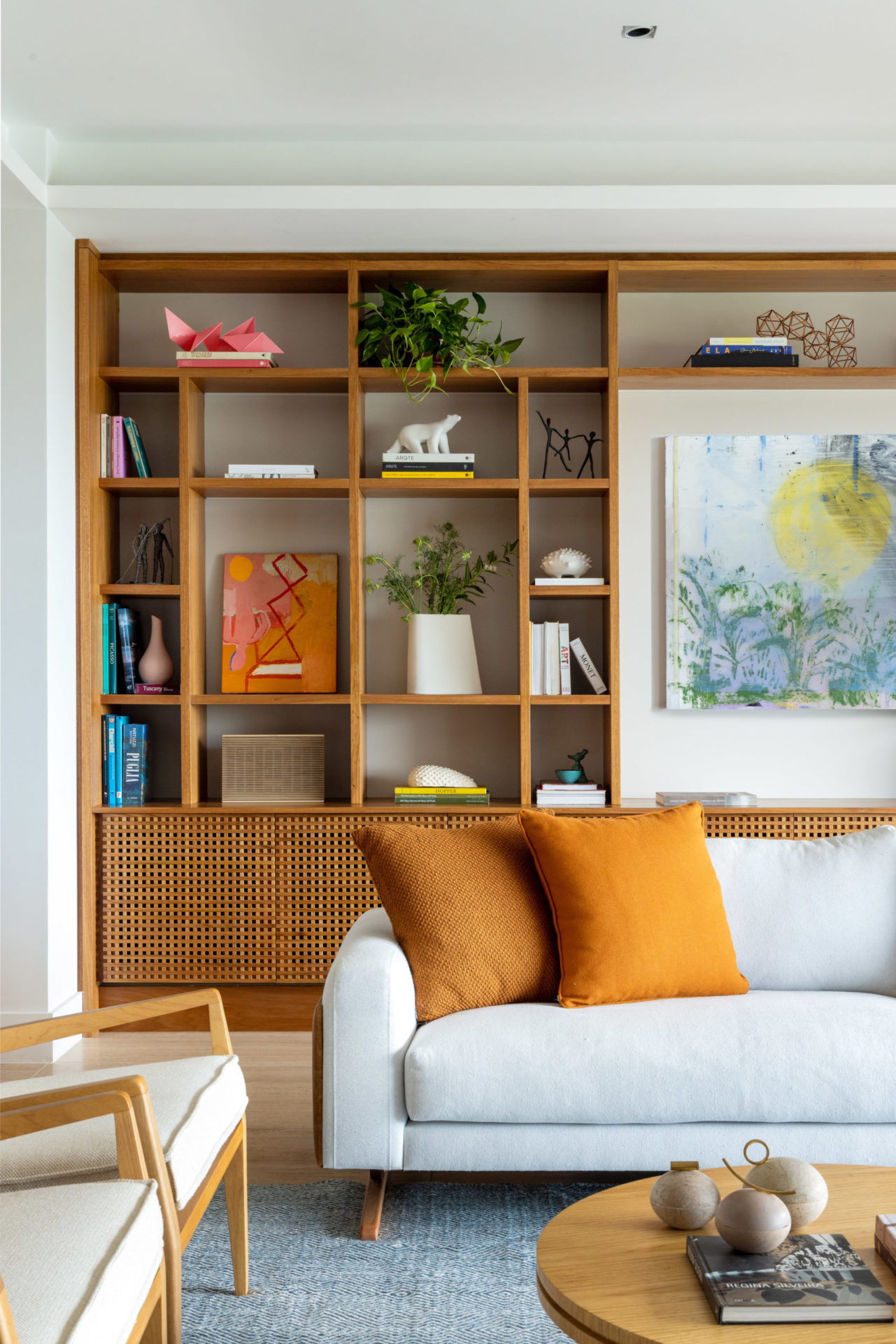 na foto sala de estar com sofá branco e almofadas