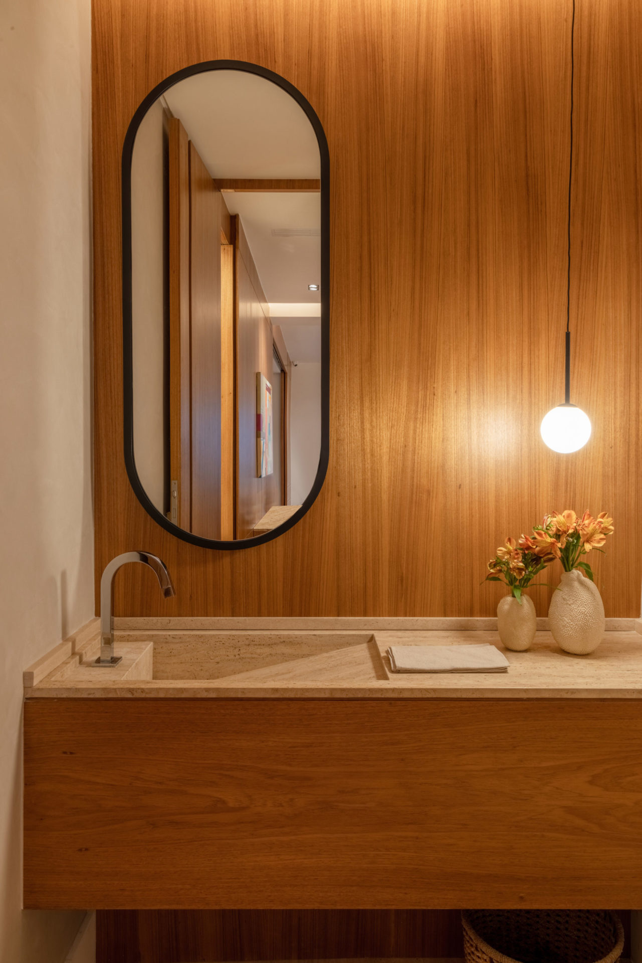 na foto lavabo com parede em madeira e espelho arredondado