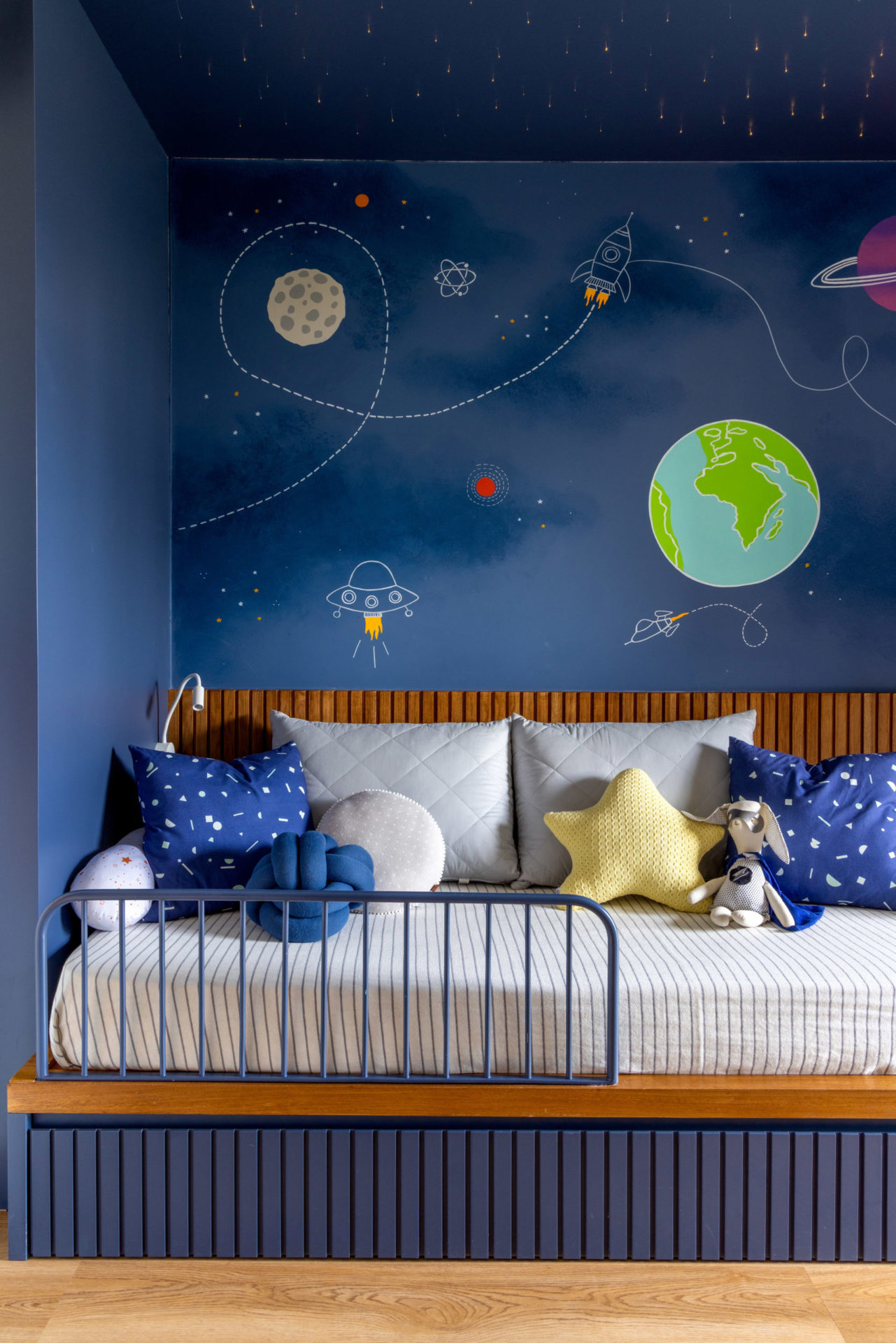 quarto infantil com tema de planetas com cama e parede azul