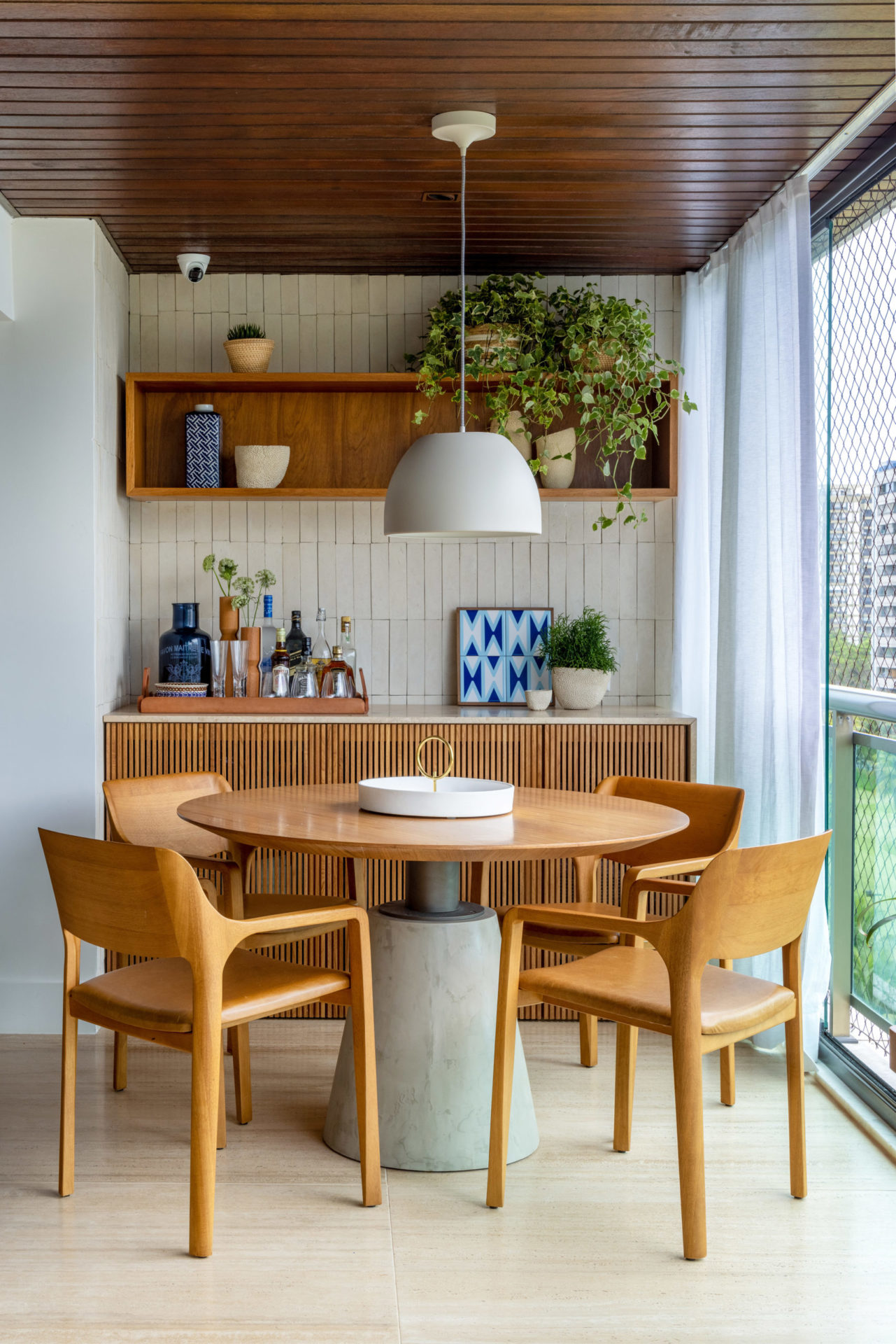 na foto mesa redonda com quatro cadeiras na varanda