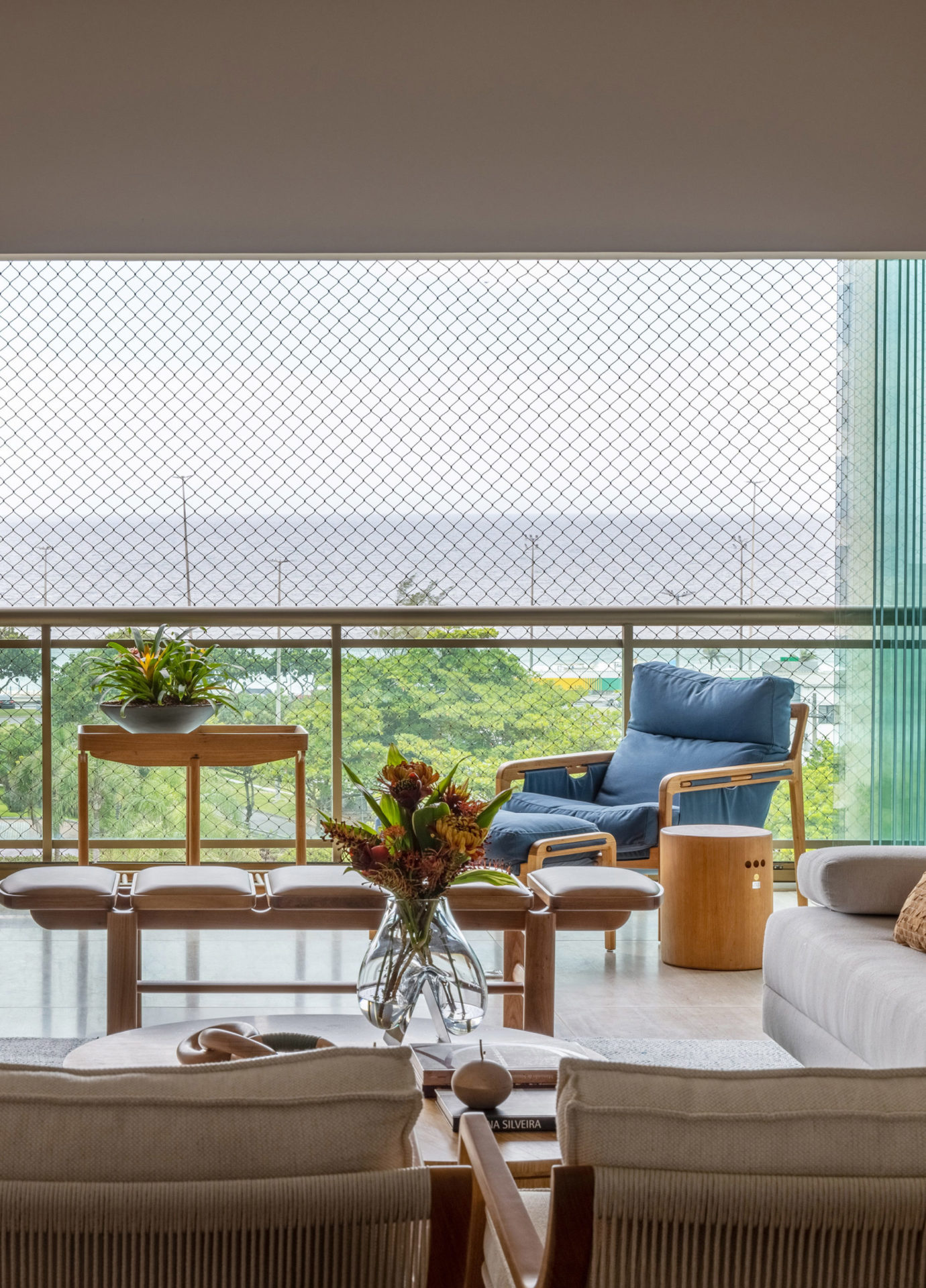 na foto varanda com poltrona, mesa e planta